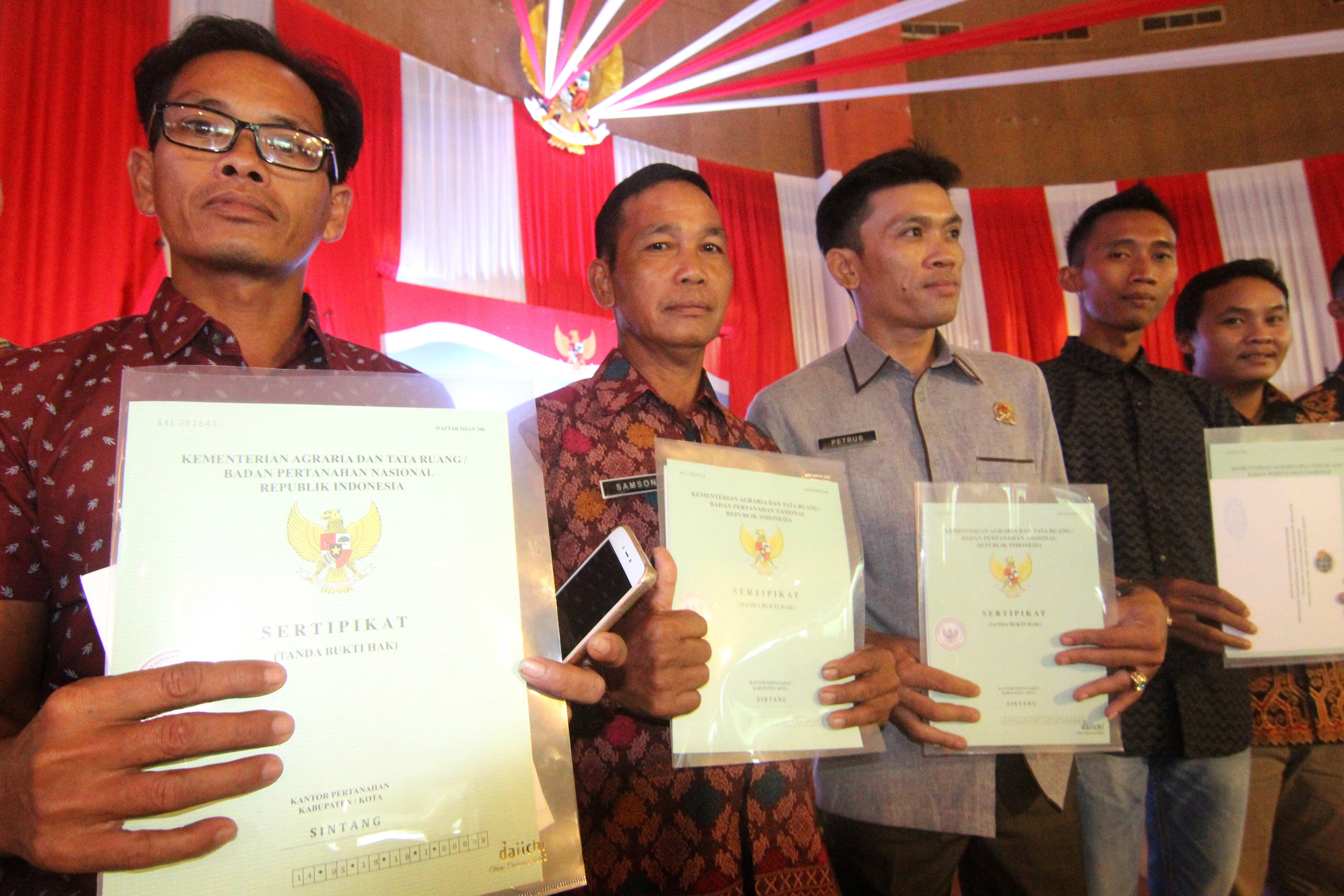 Sejumlah warga Kabupaten Sintang memperlihatkan sertifikat redistribusi tanah dari pelepasan kawasan hutan untuk rakyat yang mereka terima.