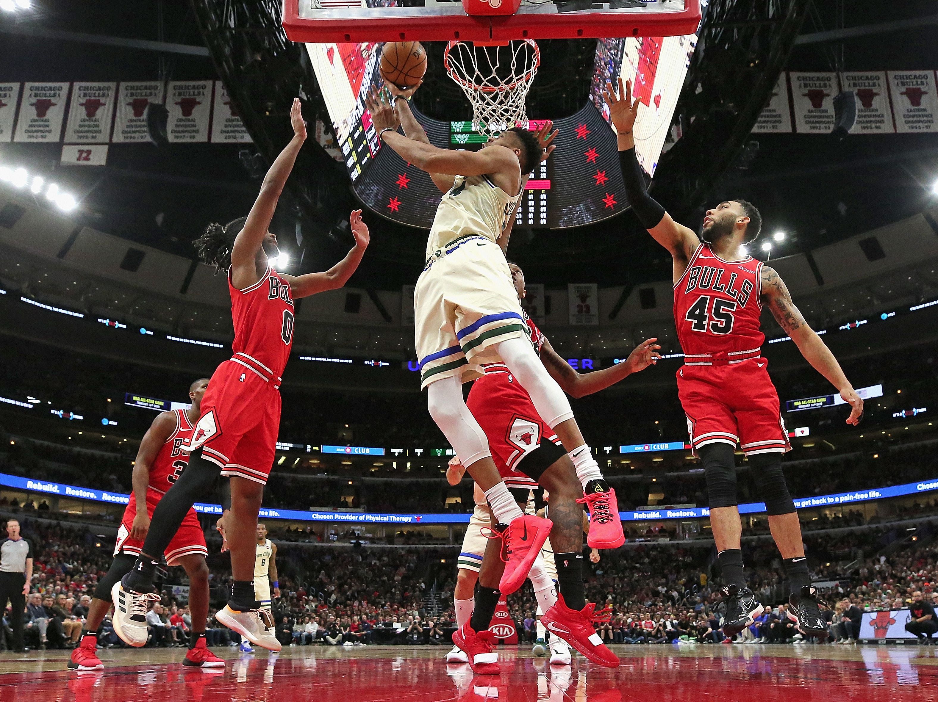 Giannis Antetokounmpo dari Milwaukee Bucks (tengah) memasukkan bola ke dalam ring