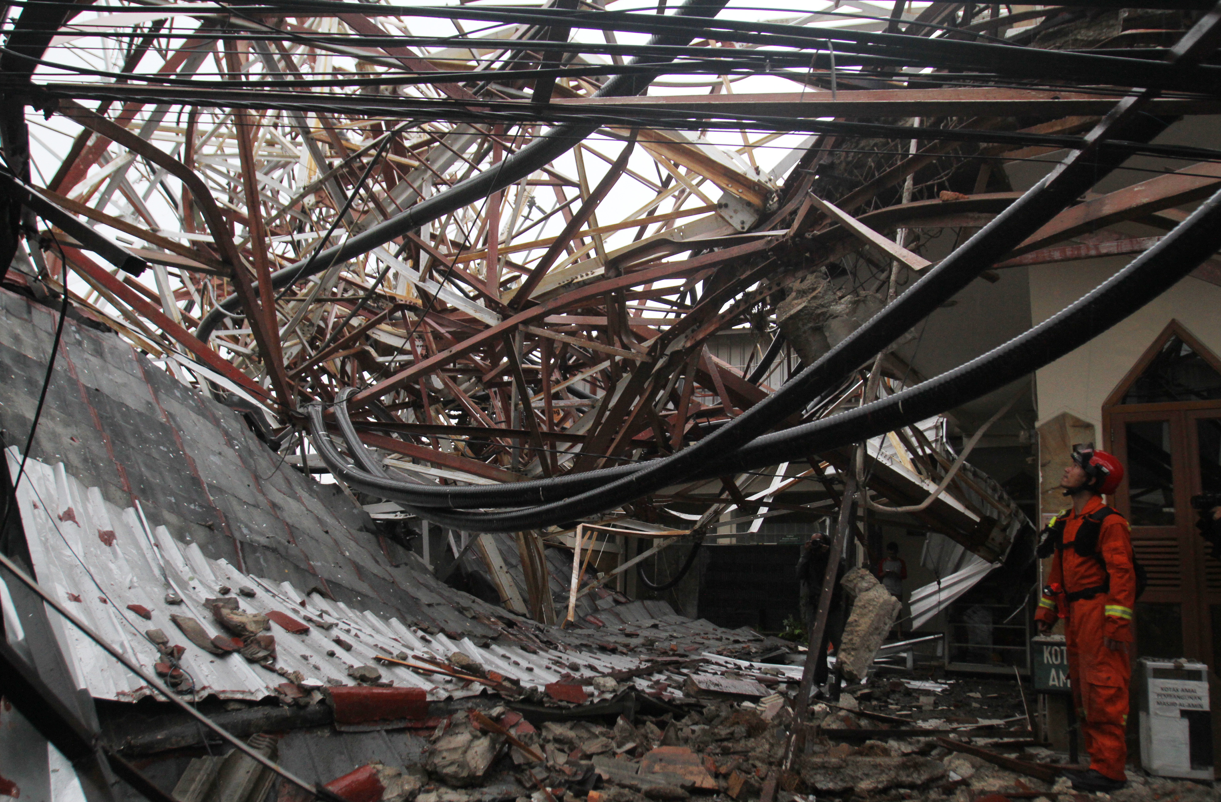 Petugas mengamati tower pemancar radio yang roboh pascahujan deras disertai angin, di kawasan Radio Dalam, Jakarta.
