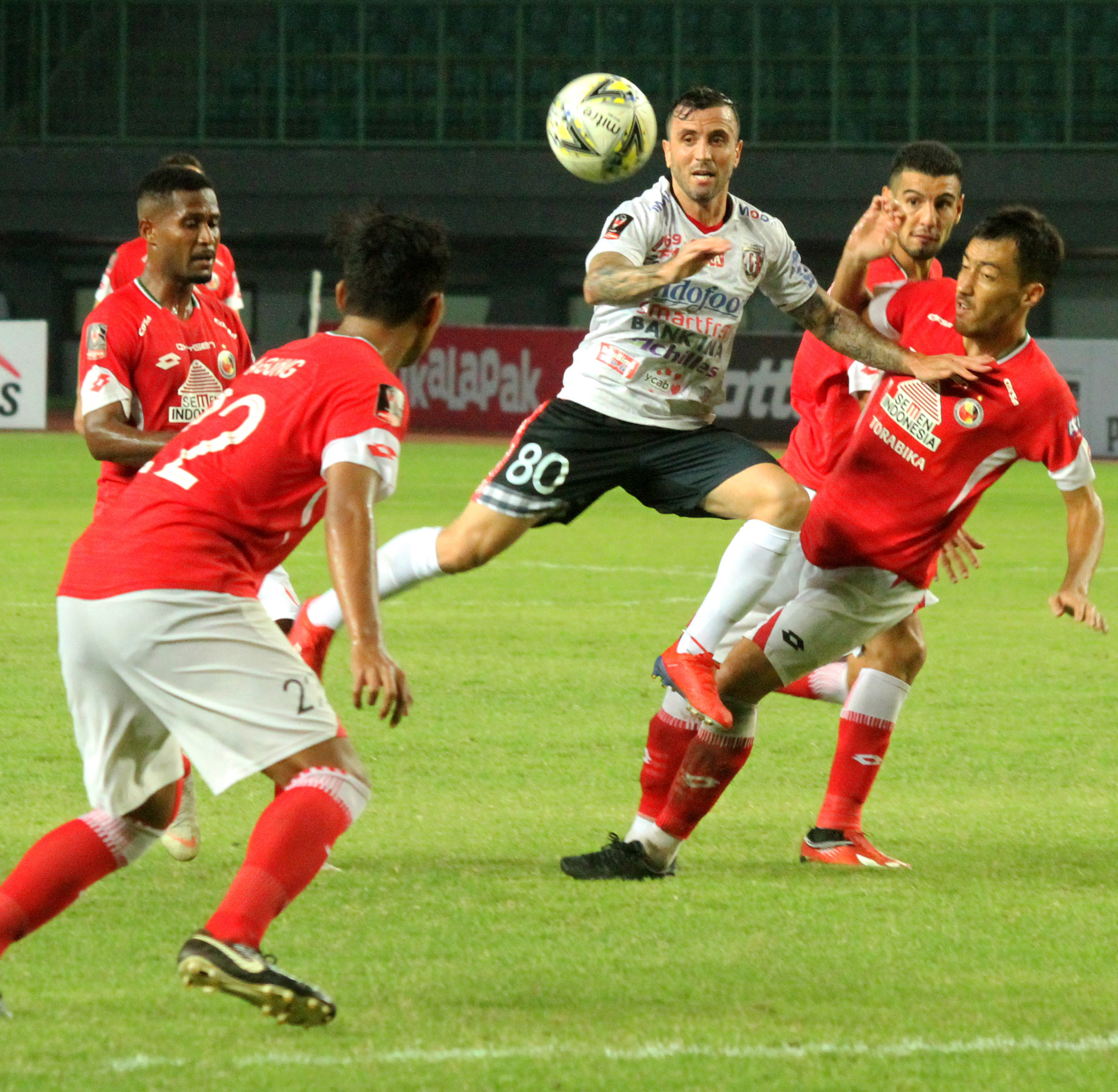 Pemain Semen Padang FC Shukurali Pulatov (kanan) berebut bola dengan pesepak bola Bali United FC Paulo Sergio Moreira Goncalves. 