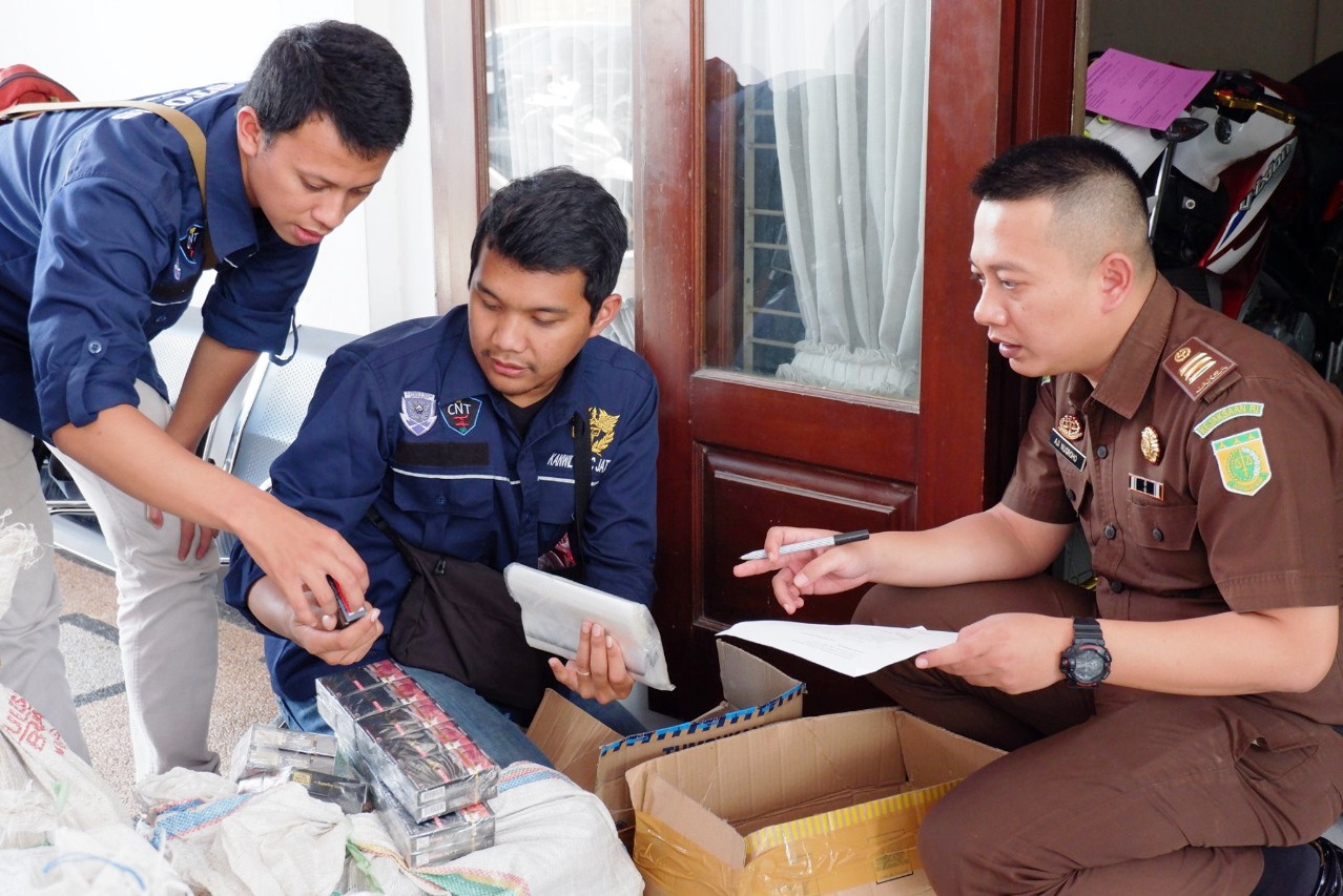 Petugas Bea Cukai dan Kejaksaan Negeri Malang sedang mendata rokok ilegal sitaan.