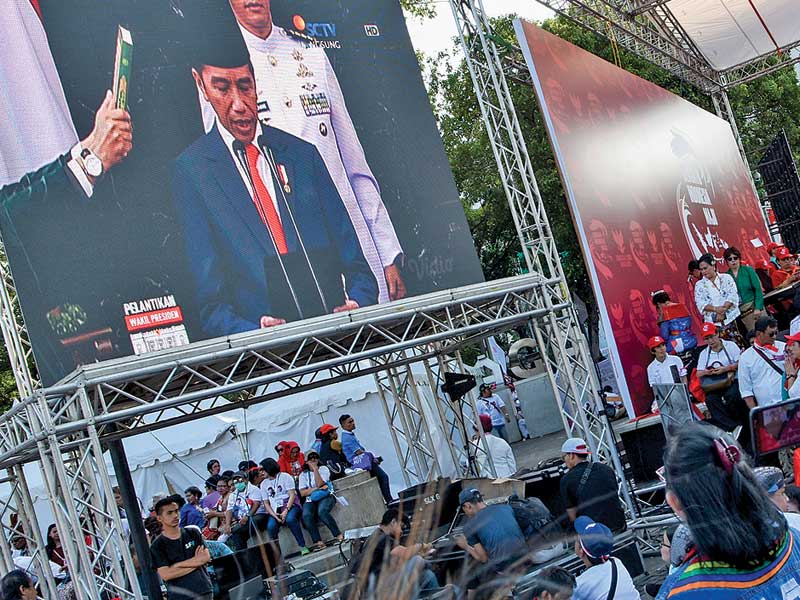 Sejumlah warga menonton bersama pelantikan presiden dan wakil presiden terpilih periode 2019-2024 Joko Widodo-Ma’ruf Amin melalui layar.