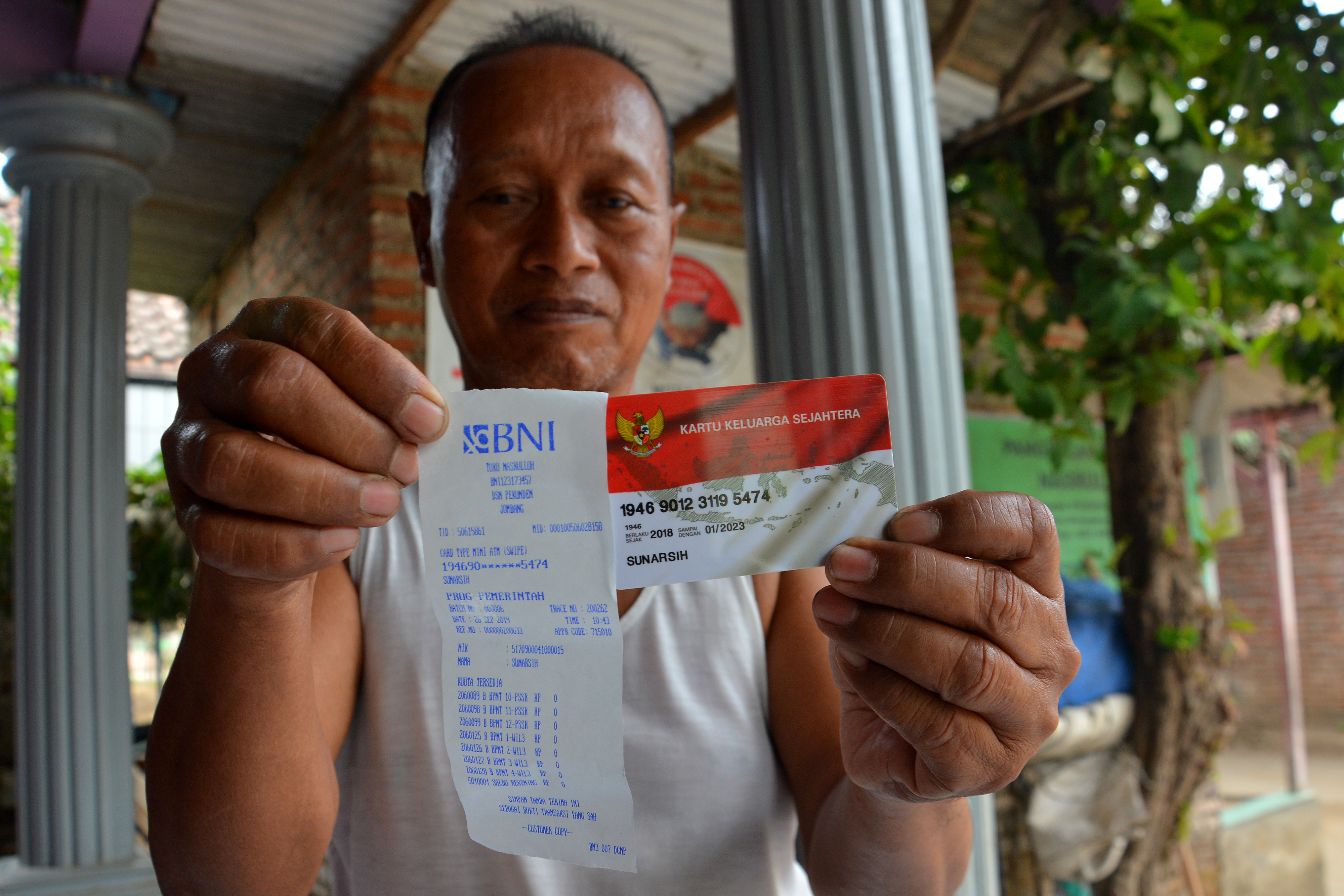 Seorang warga menunjukkan kartu keluarga sejahtera. Bansos yang digelontorkan ke NTT tidak tepat sasaran. 