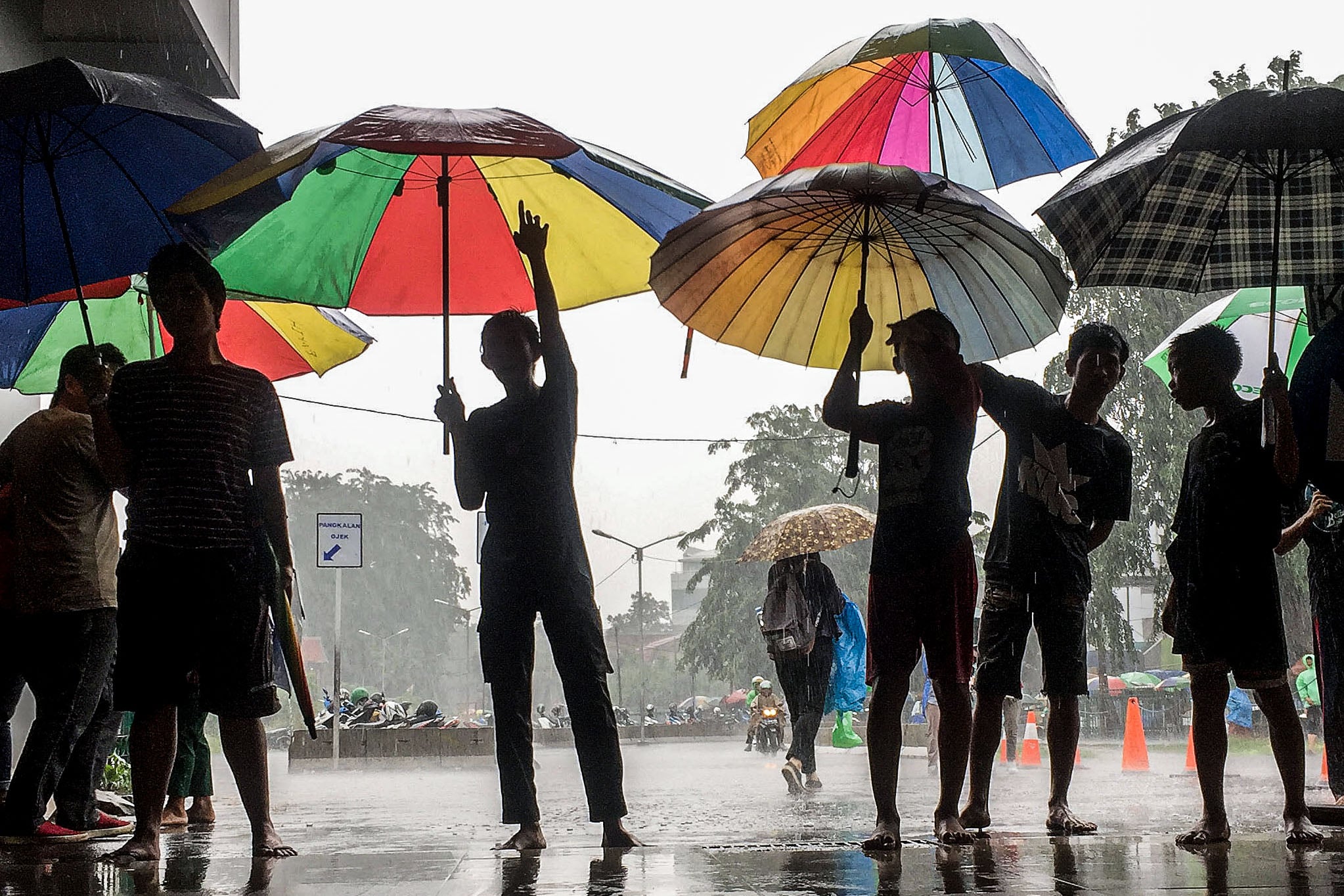 Ojek payung menunggu penumpang Commuterline di Stasiun Tanah Abang.