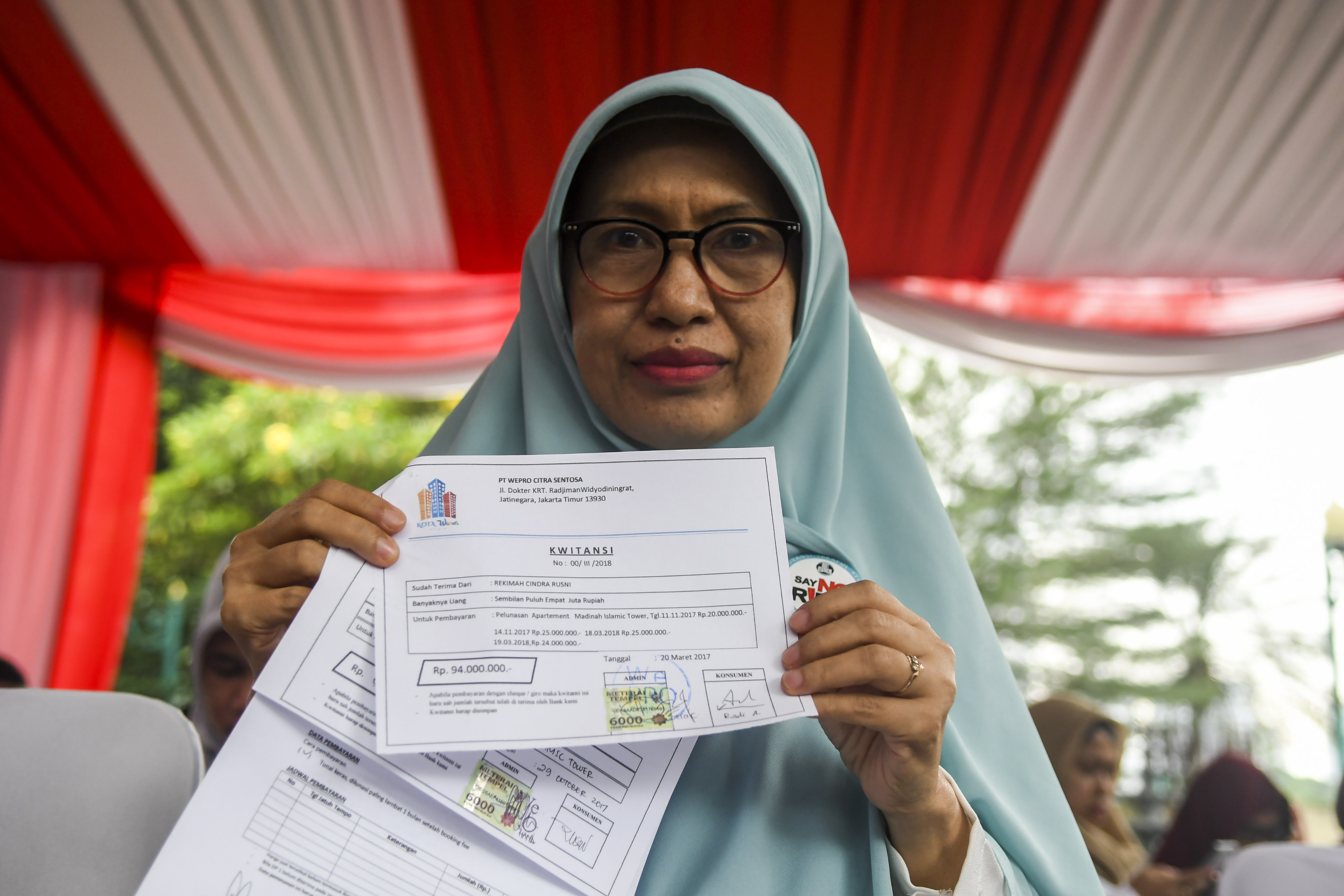 Korban kasus sindikat mafia perumahan syariah menunjukan bukti transaksi pembelian rumah saat hadir dalam rilis kasus di Polda Metro Jaya.