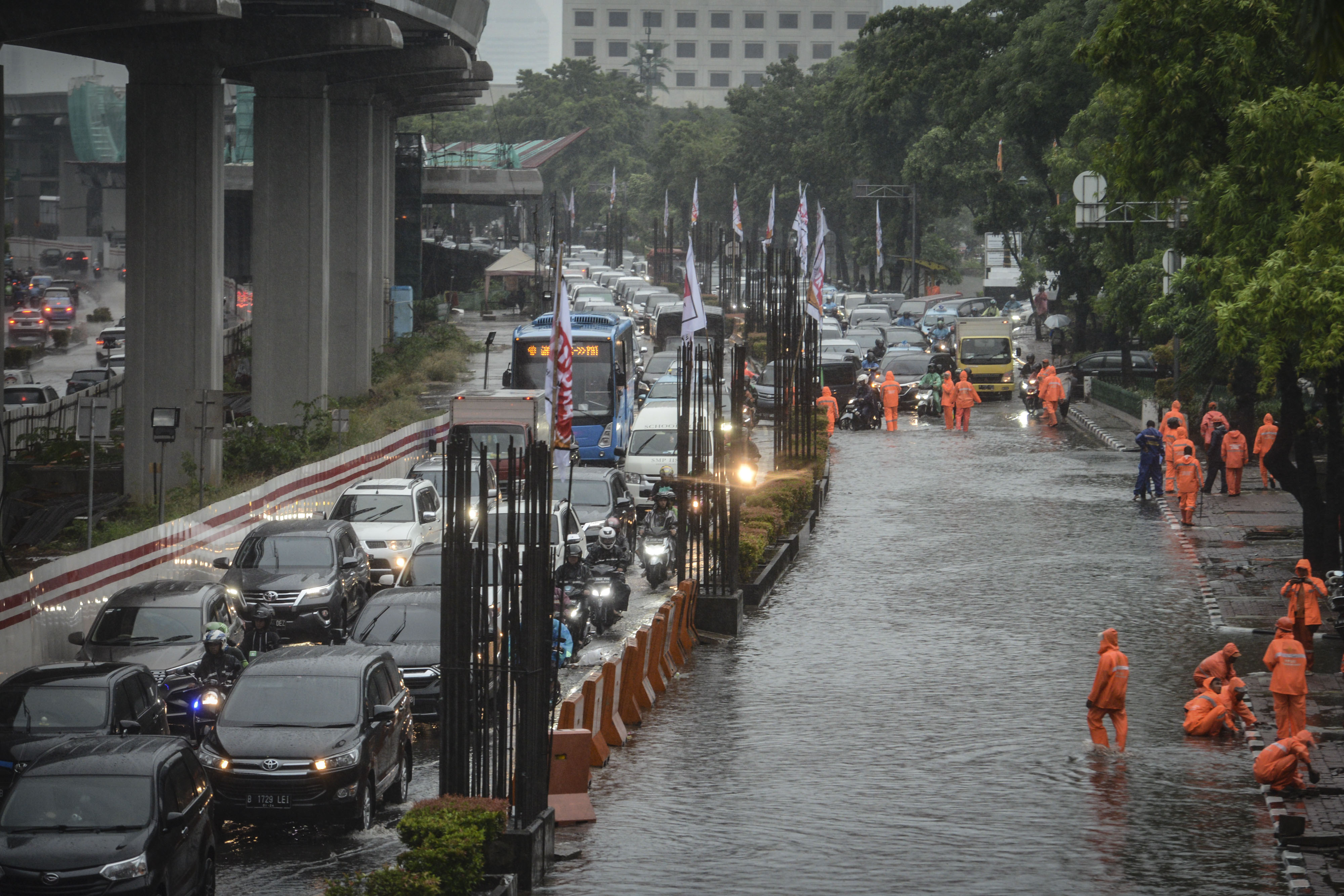  Kendaraan melintas di samping genangan banjir di Jalan HR Rasuna Said, Kuningan, Jakarta, Selasa (17/12). 