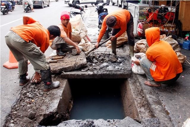 Para petugas PPSU DKI sedang membersihkan saluran air yang tersumbat di wilayah Ibu Kota.