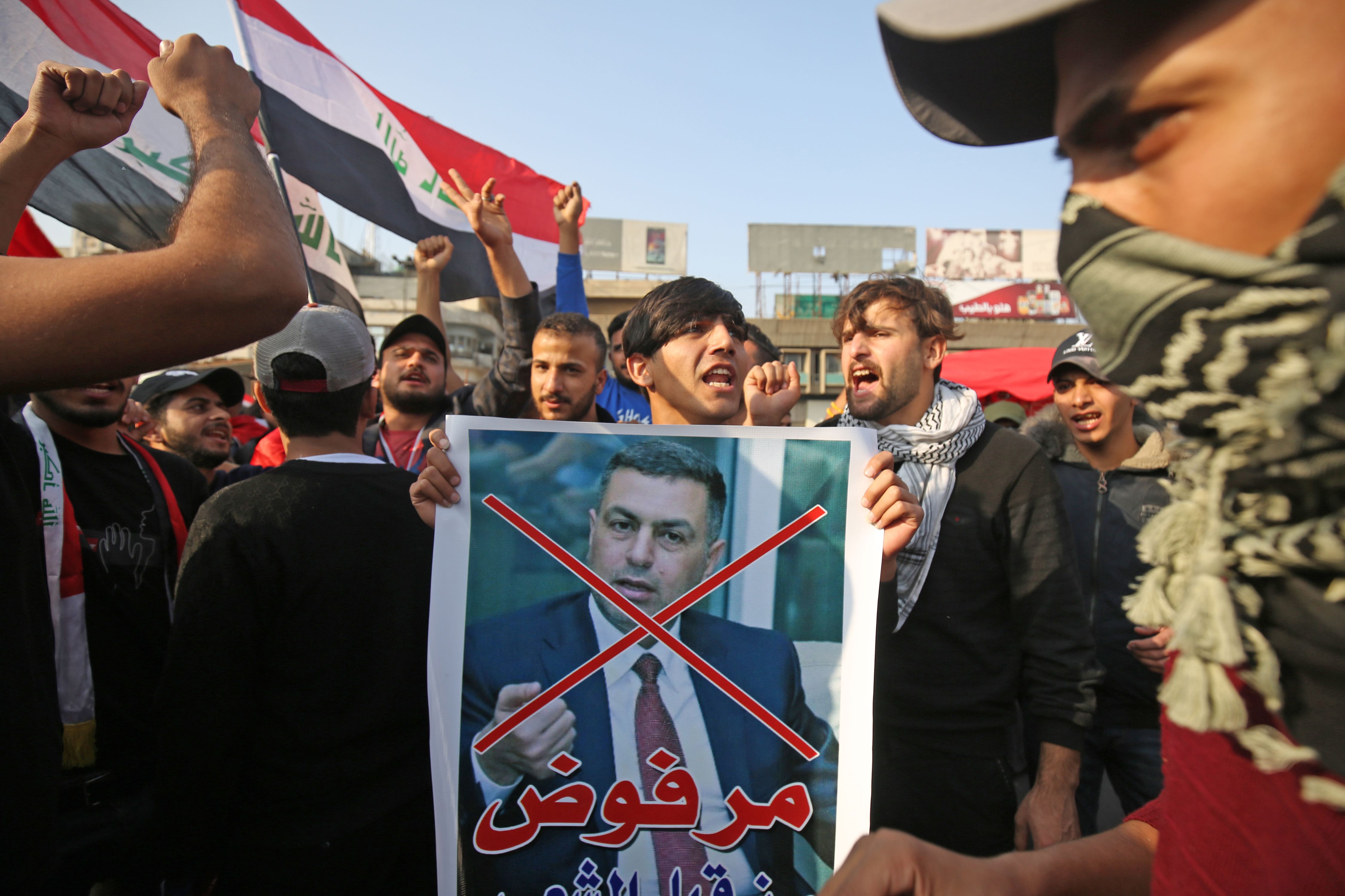 Demonstran anti-pemerintah Irak bernujuk rasa dengan membawa foto Assaad al-Aidani, Gubernur Basra, yang dicalonkan jadi perdana menteri.