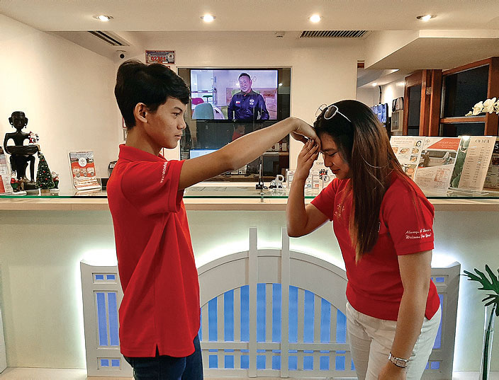 Dua warga Filipina memperagakan mano po yang merupakan cara seseorang untuk menghormati orang tua.