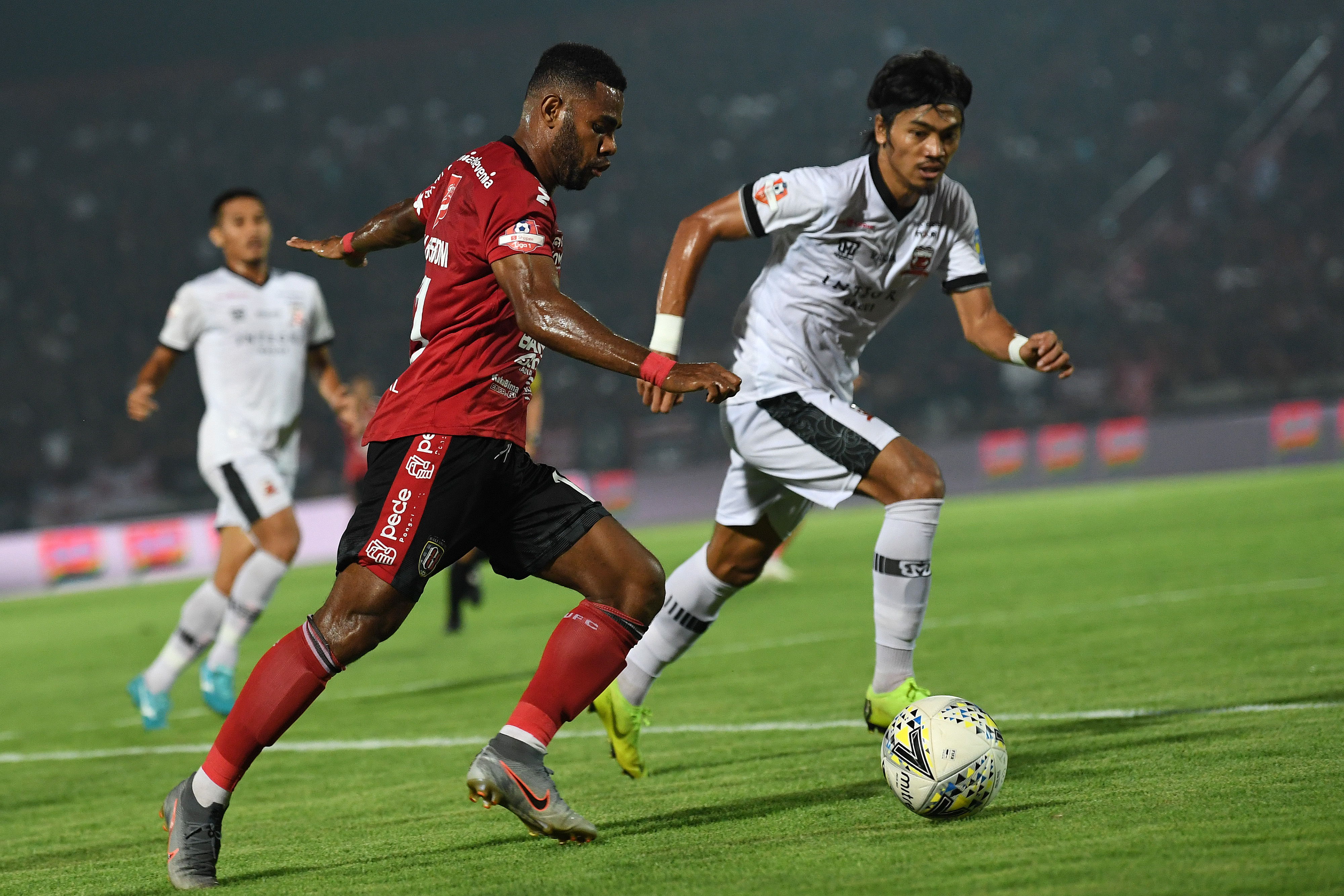 Pesepak bola Bali United Yabes Roni Malaifani (kiri) menggiring bola yang dibayangi pesepak bola Madura United Andik Rendika Rama (kanan)