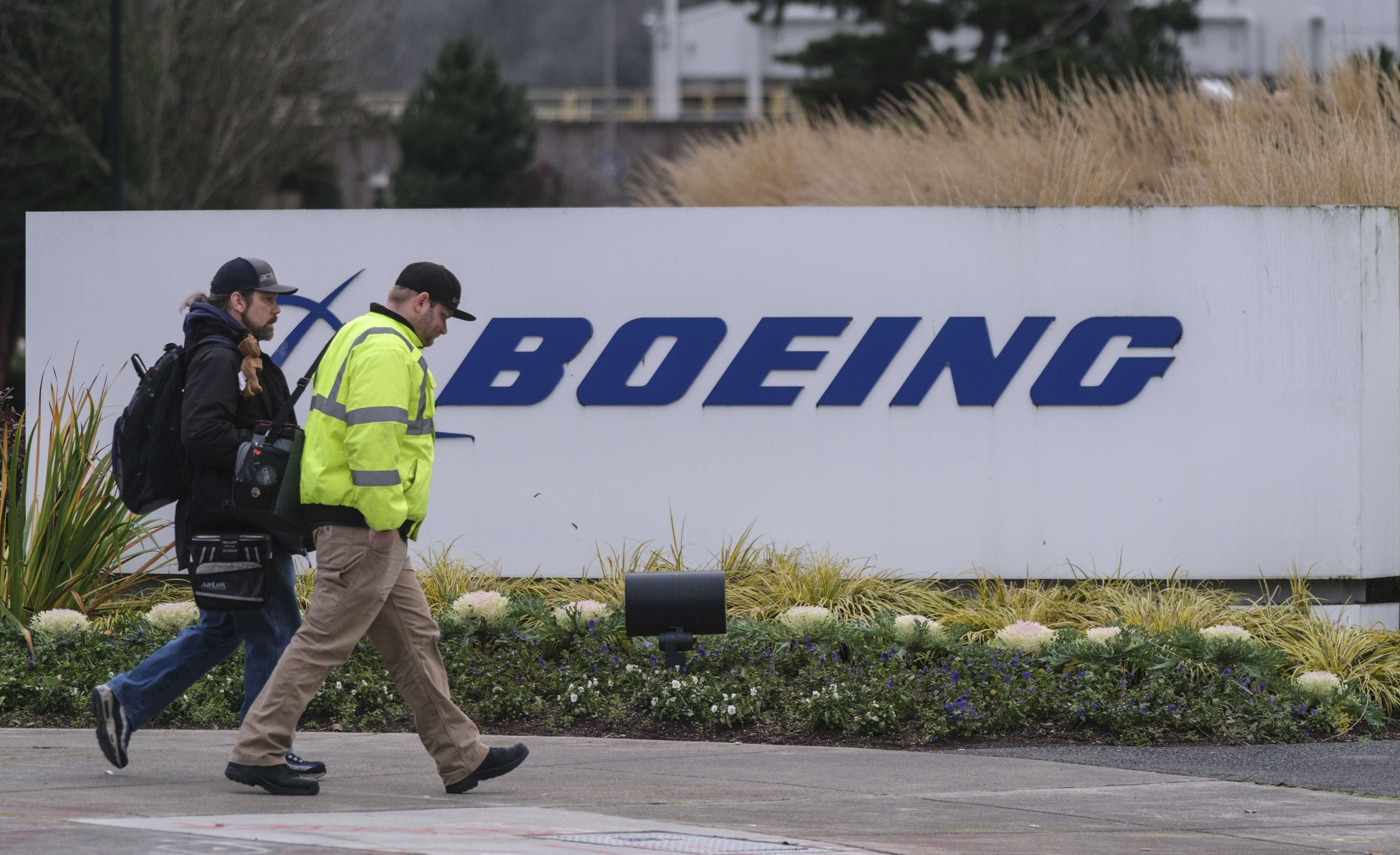 Dua karyawan berjalan di depan logo perusahaan Boeing di Renton, Washington, Amerika Serikat