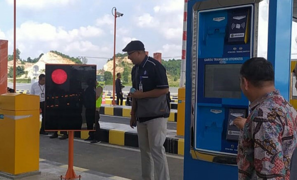 Seorang petugas menguji alat pembaca uang elektronik di tol Balikpapan-Samarinda