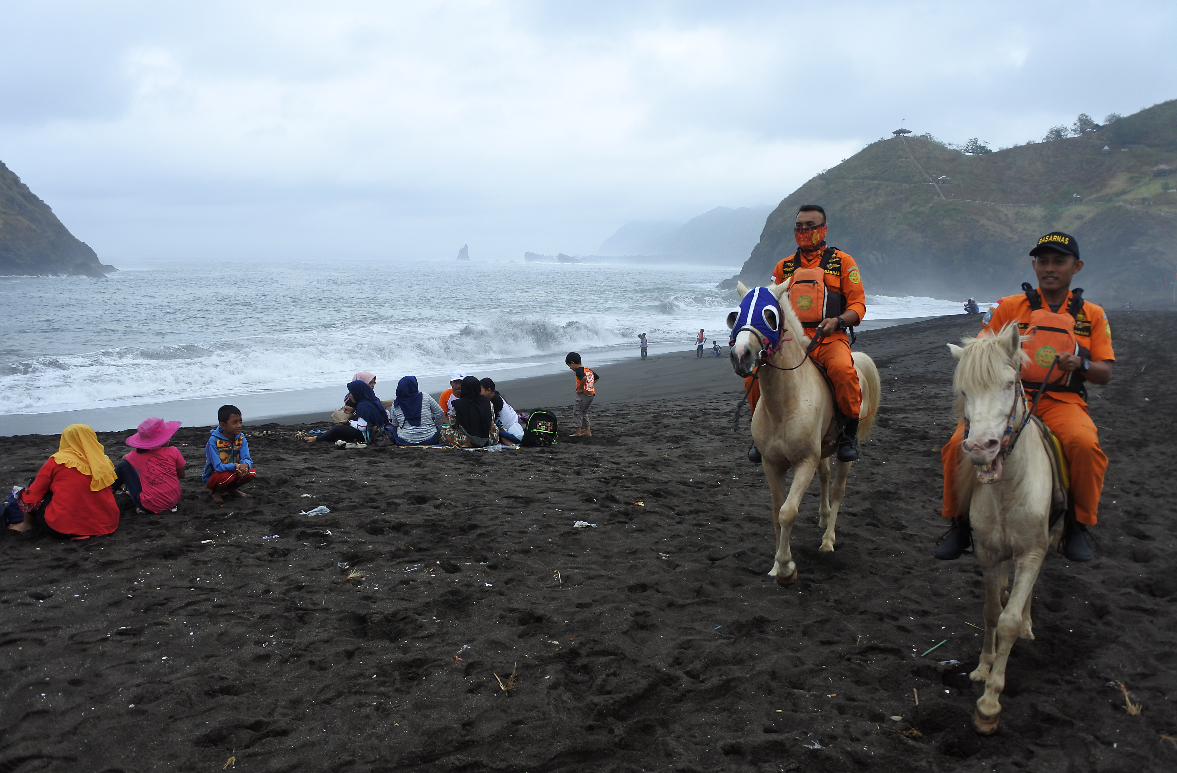 Dua petugas SAR berpatroli menggunakan kuda di Pantai Payangan, Ambulu, Jember, Jawa Timur, beberapa waktu lalu.