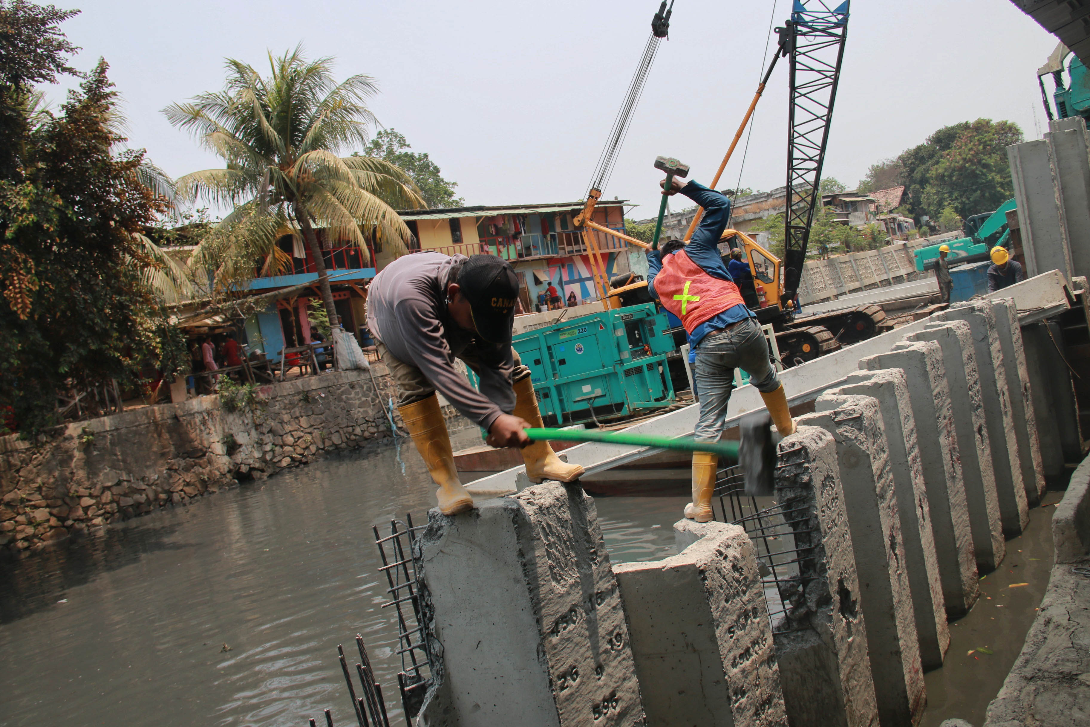 Pekerja menyelesaikan pembangunan tanggul sungai di Kali Krukut, Jakarta Utara, Selasa (8/10).