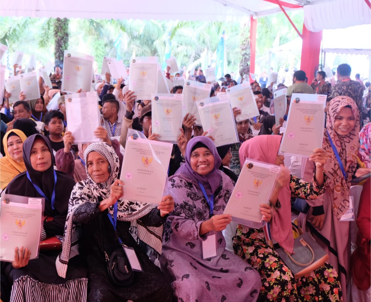 Masyarakat memasang wajah ceria usai penyerahan 3.000 serifikat di Kampar, Riau, Kamis (26/12).