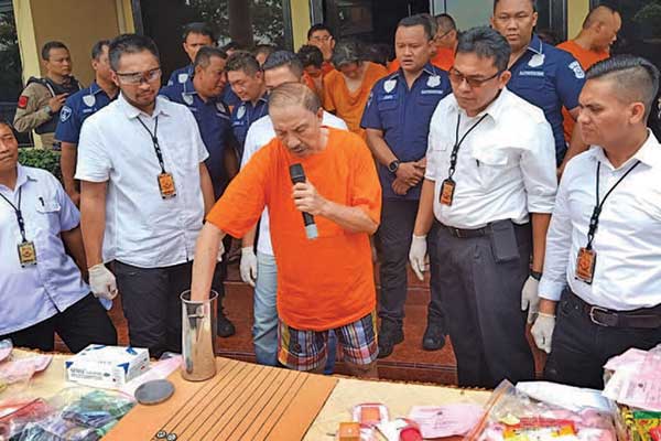 Seorang bandar memperagakan permainan judi batu goncang saat rilis pengungkapan judi di Polres Metro Jakarta Barat, kemarin.