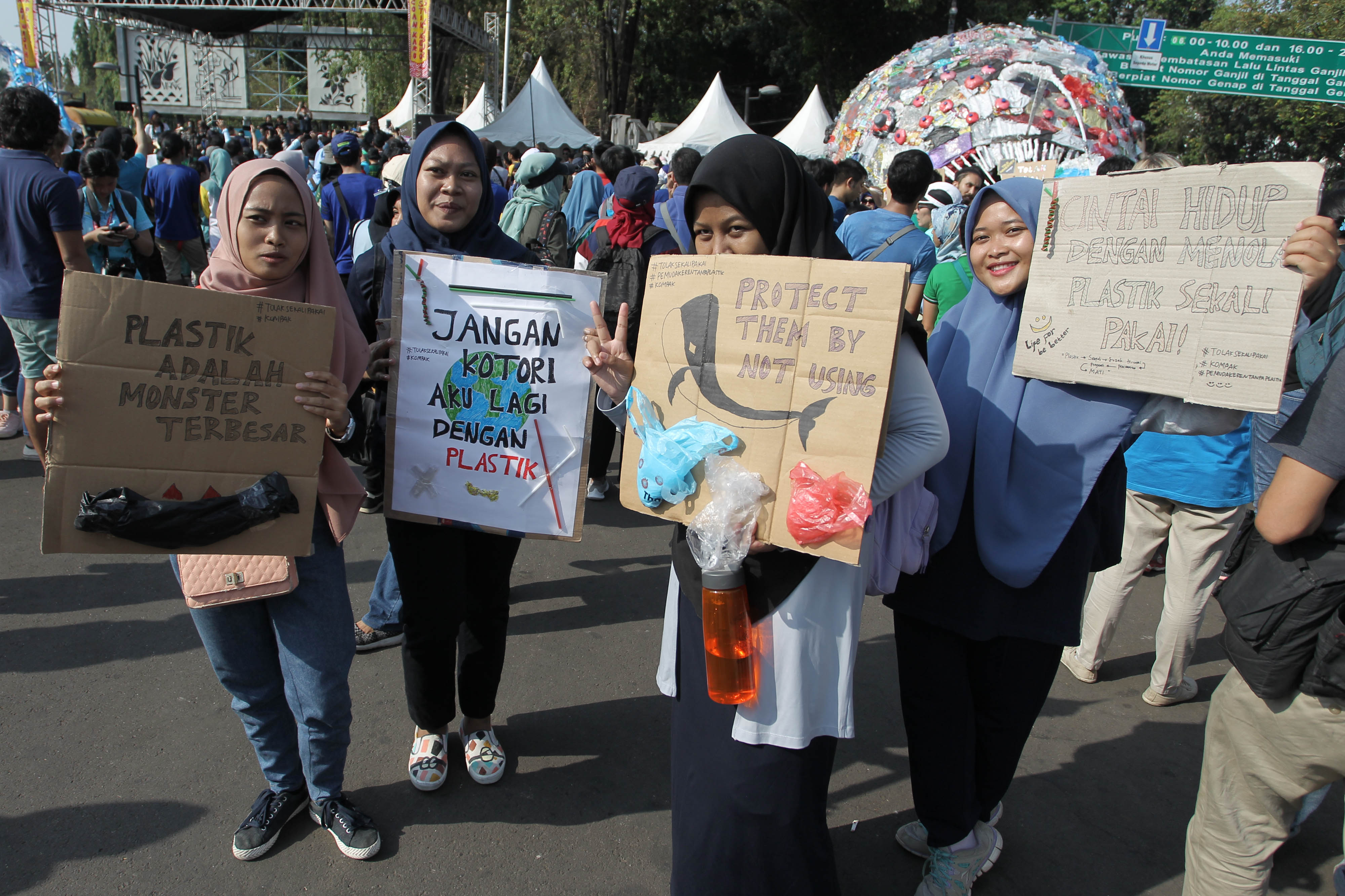 Sejumlah Aktivis menunjukan poster mengampanyekan Tolak Plastik Sekali Pakai saat hari bebas kendaraan bermotor di Taman Inspirasi Monas