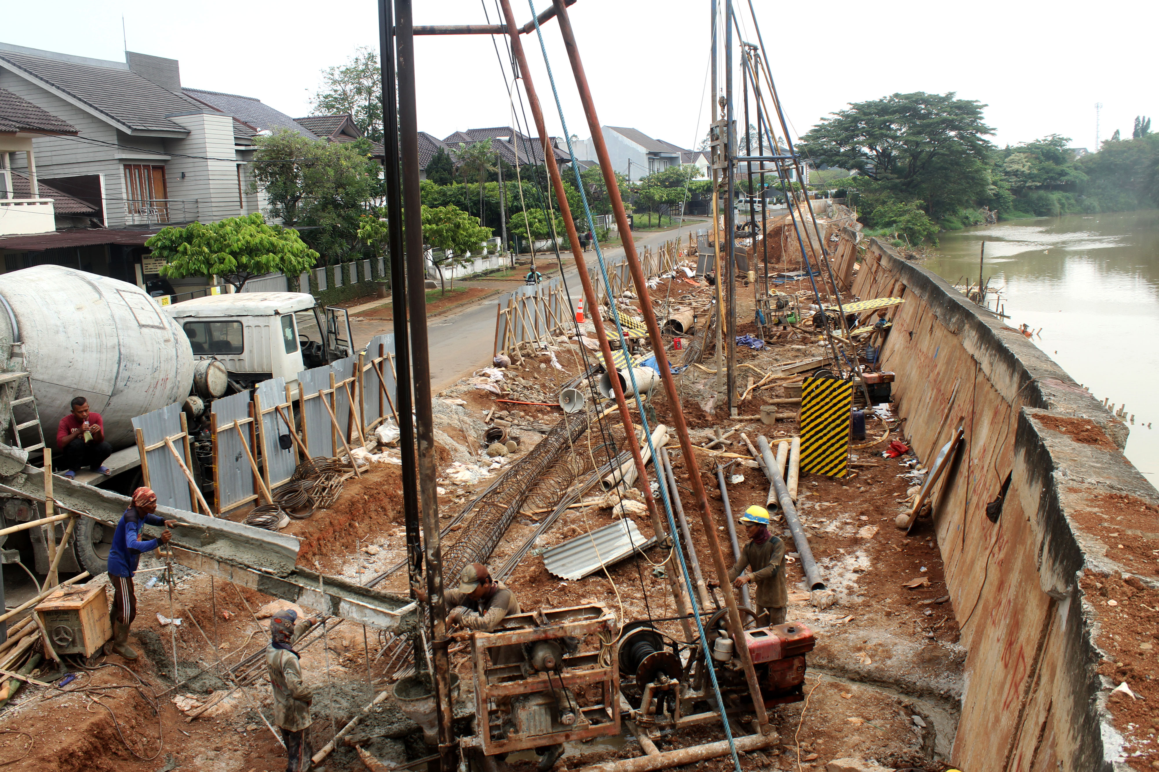 Pekerja mengerjakan perbaikan tanggul sungai yang amblas, di kawasan Kemang Pratama, Bekasi, Jawa Barat, Selasa (5/11). 