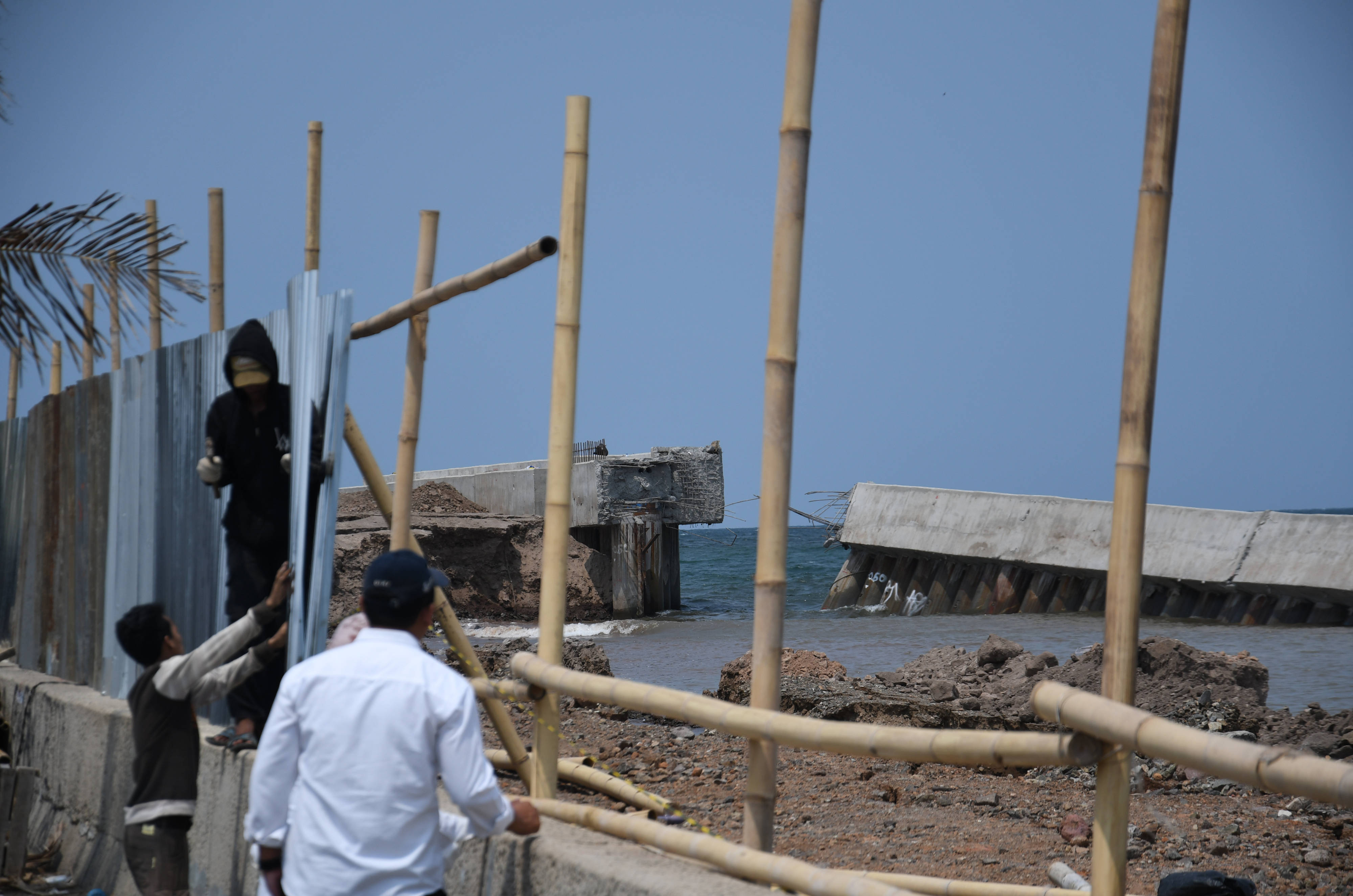 Pekerja memasang bambu dan seng untuk menutupi tanggul NCICD di Muara Baru, Jakarta Utara, yang jebol, Rabu (4/12/2019)