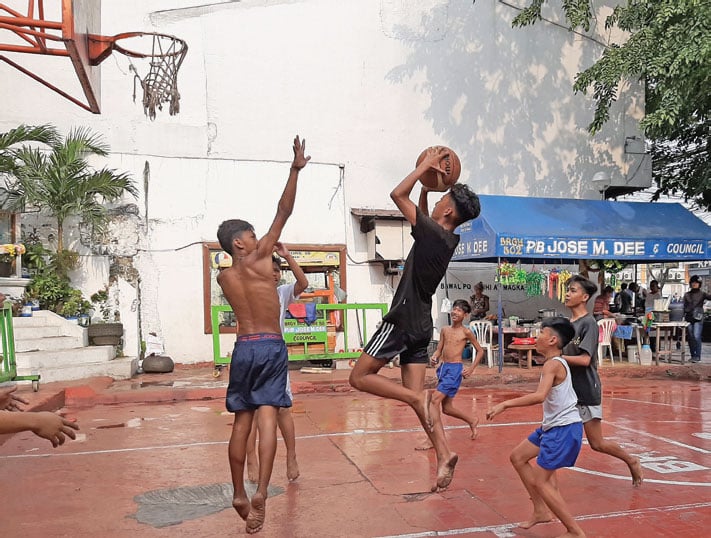 Anak-anak Filipina bermain bola basket di Sampaloc, Manila, Sabtu (7/12).