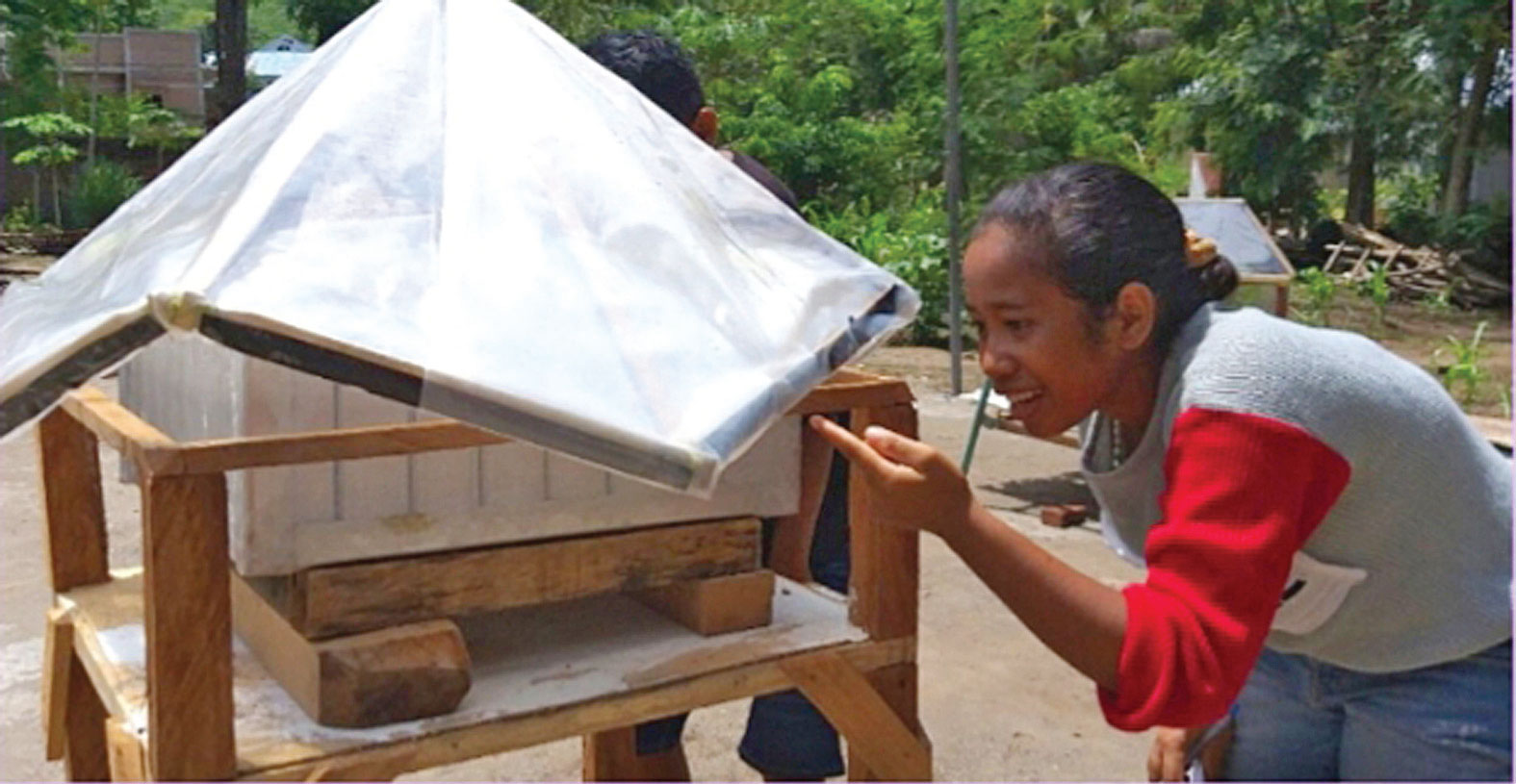 PENYULING AIR: Marie Hermine Eka Putri memperhatikan alat penyuling air buatannya