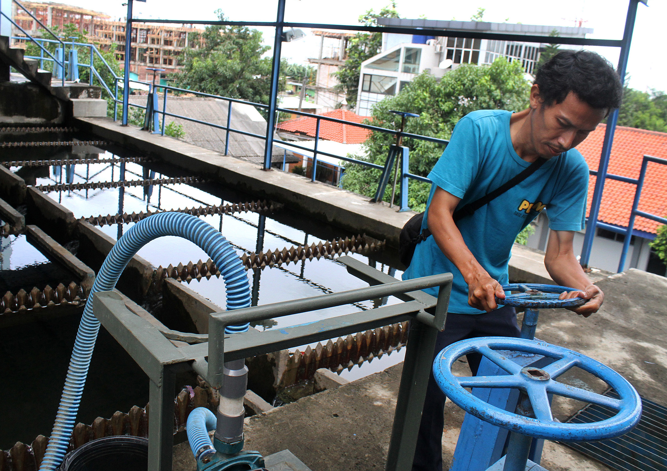 Pekerja mengoperasikan kolam pengolahan air bersih di instalasi Water Treatment Plant (WTP) PDAM Tirta Patriot Bekasi