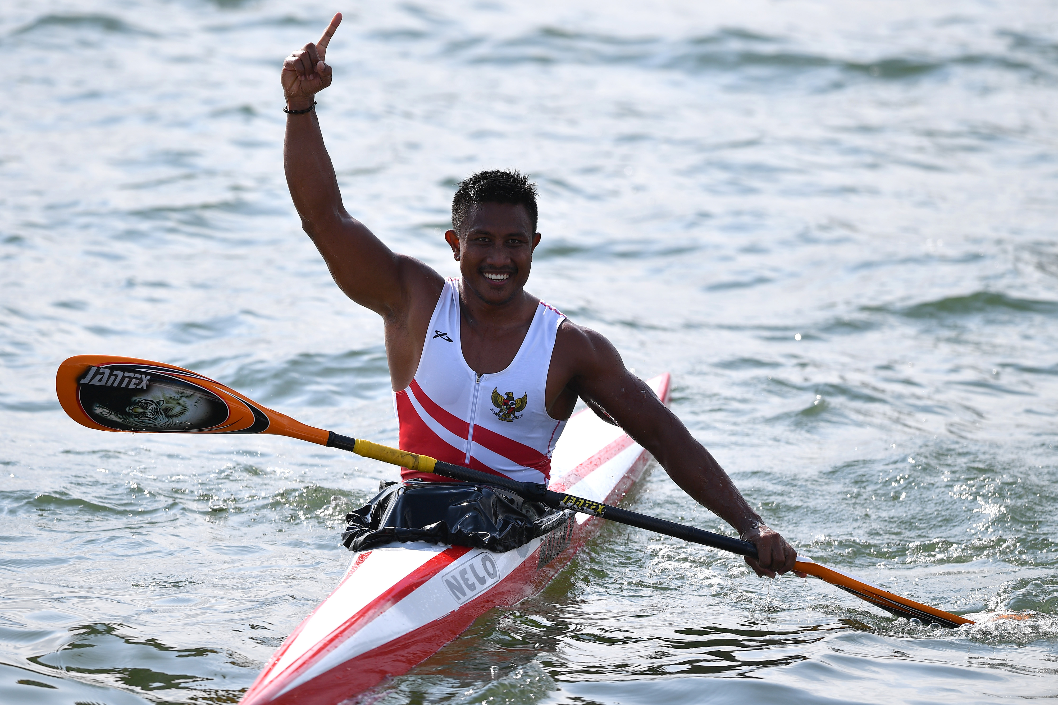 Atlet dayung Indonesia Maizir Ryondra melakukan selebrasi seusai memasuki garis finish.