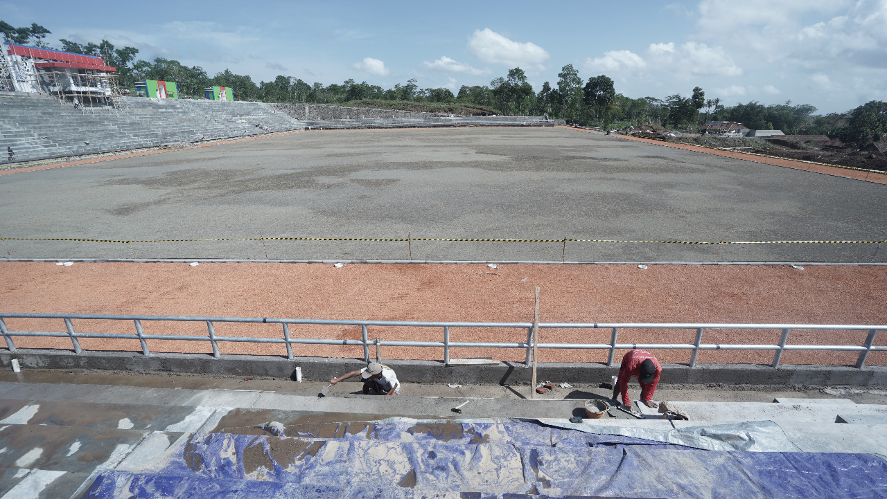 Dua pekerja sedang mengerjakan Stadion Kebo Giro.