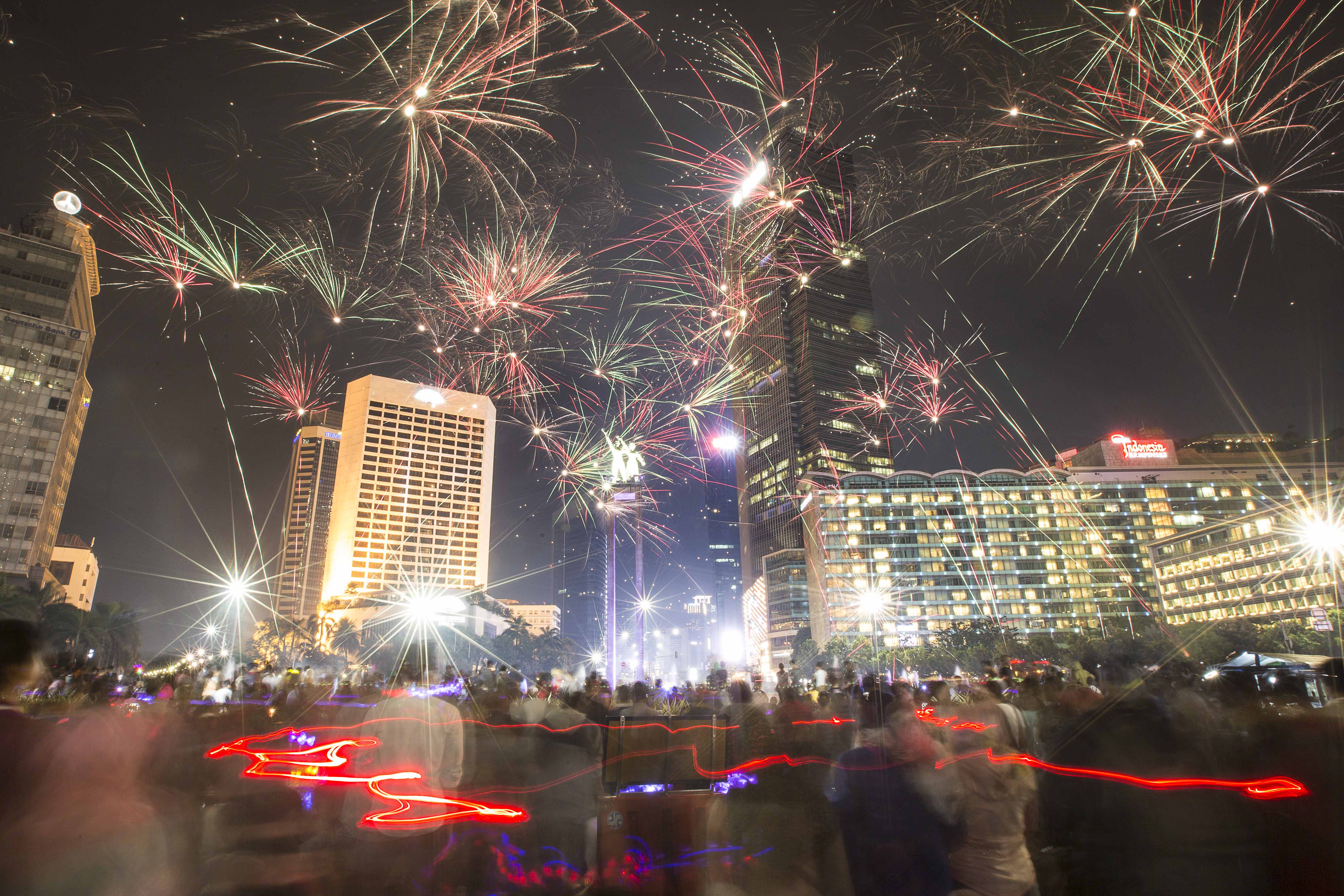Warga menyalakan kembang api saat pergantian tahun baru di Bundaran HI, Jakarta.