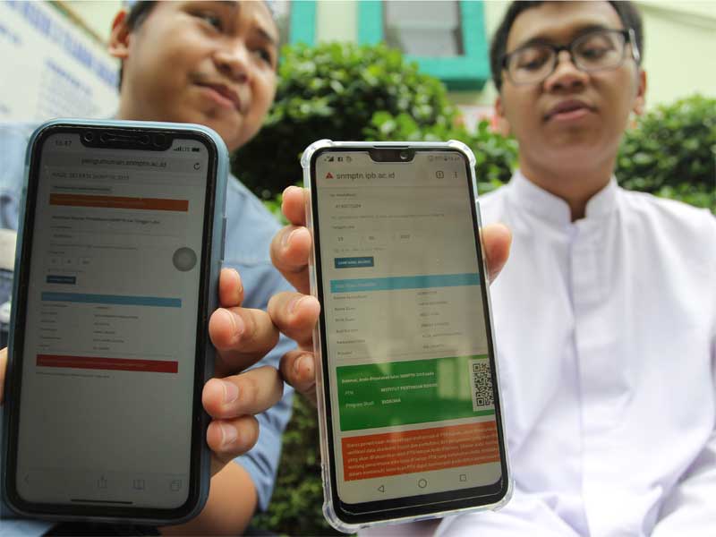 Dua orang siswa Sekolah Menengah Atas Negeri 3 Jakarta menunjukan perbedaan hasil saat mengakses situs resmi Seleksi Nasional Masuk SNMPTN.