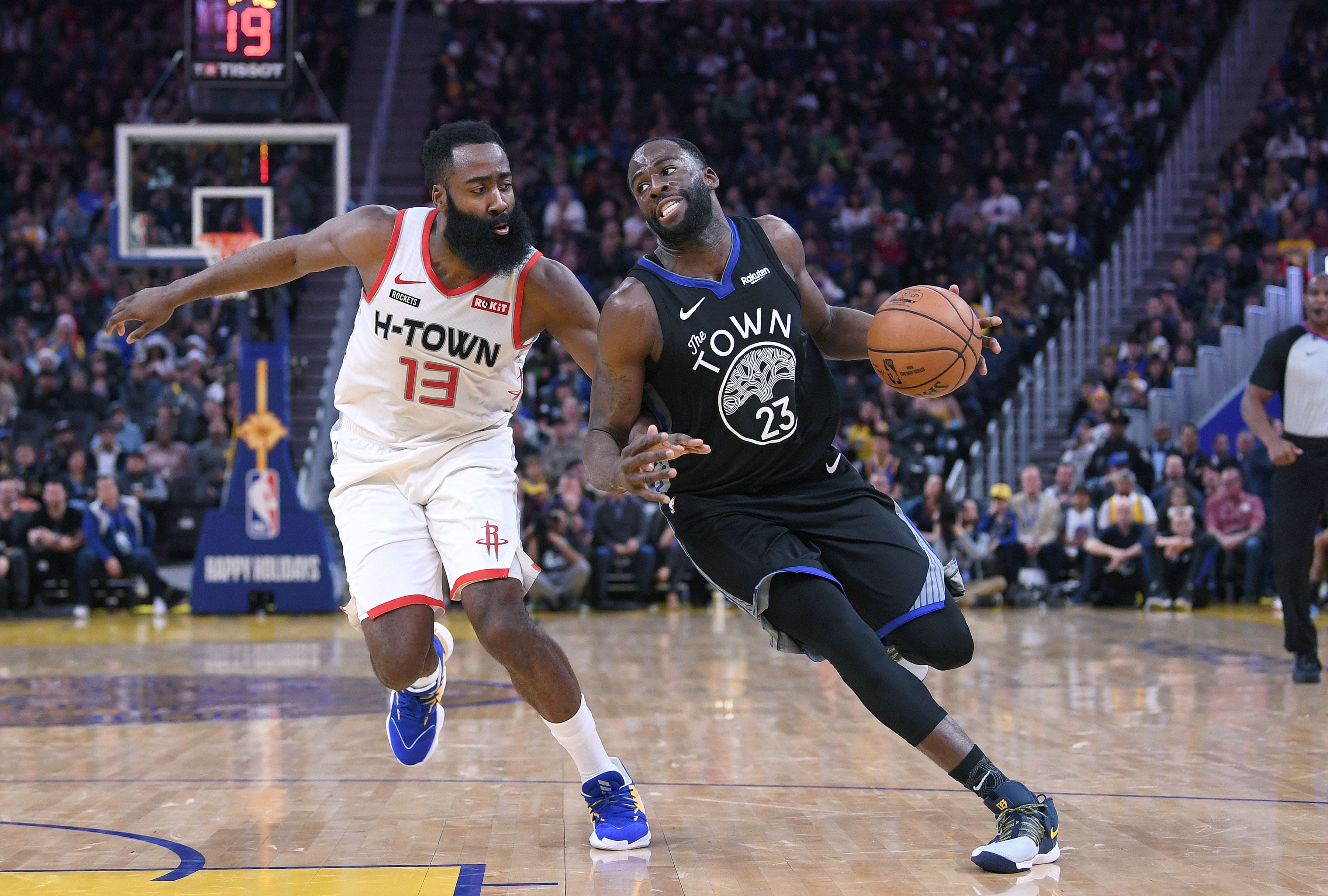 Draymond Green (kanan) dari Golden State Warriors mencoba melewati bintang Houston Rockets James Harden pada laga di Chase Center.