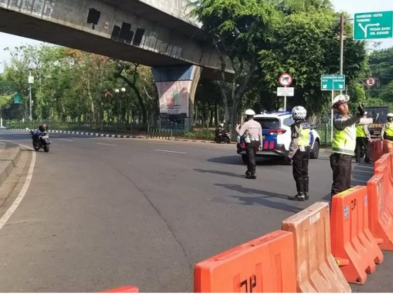 Polisi berjaga di lintasan Jalan Medan Merdeka Timur yang ditutup bagi pengendara usai ledakan terjadi pada Selasa (3/12)