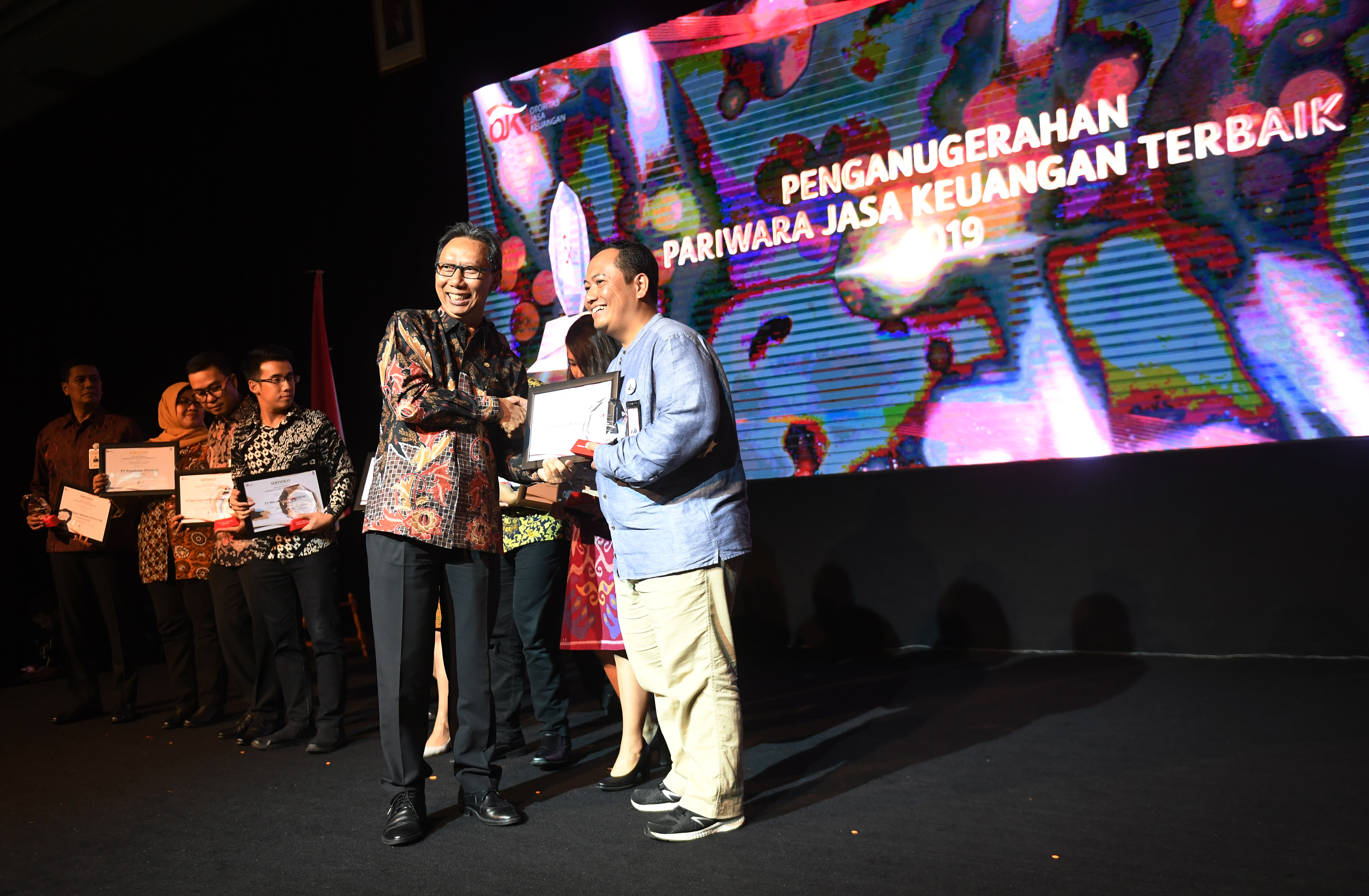 Anggota Dewan Komisioner OJK Tirta Segara (kiri) memberikan penghargaan dalam acara Penganugerahan Pariwara Jasa Keuangan