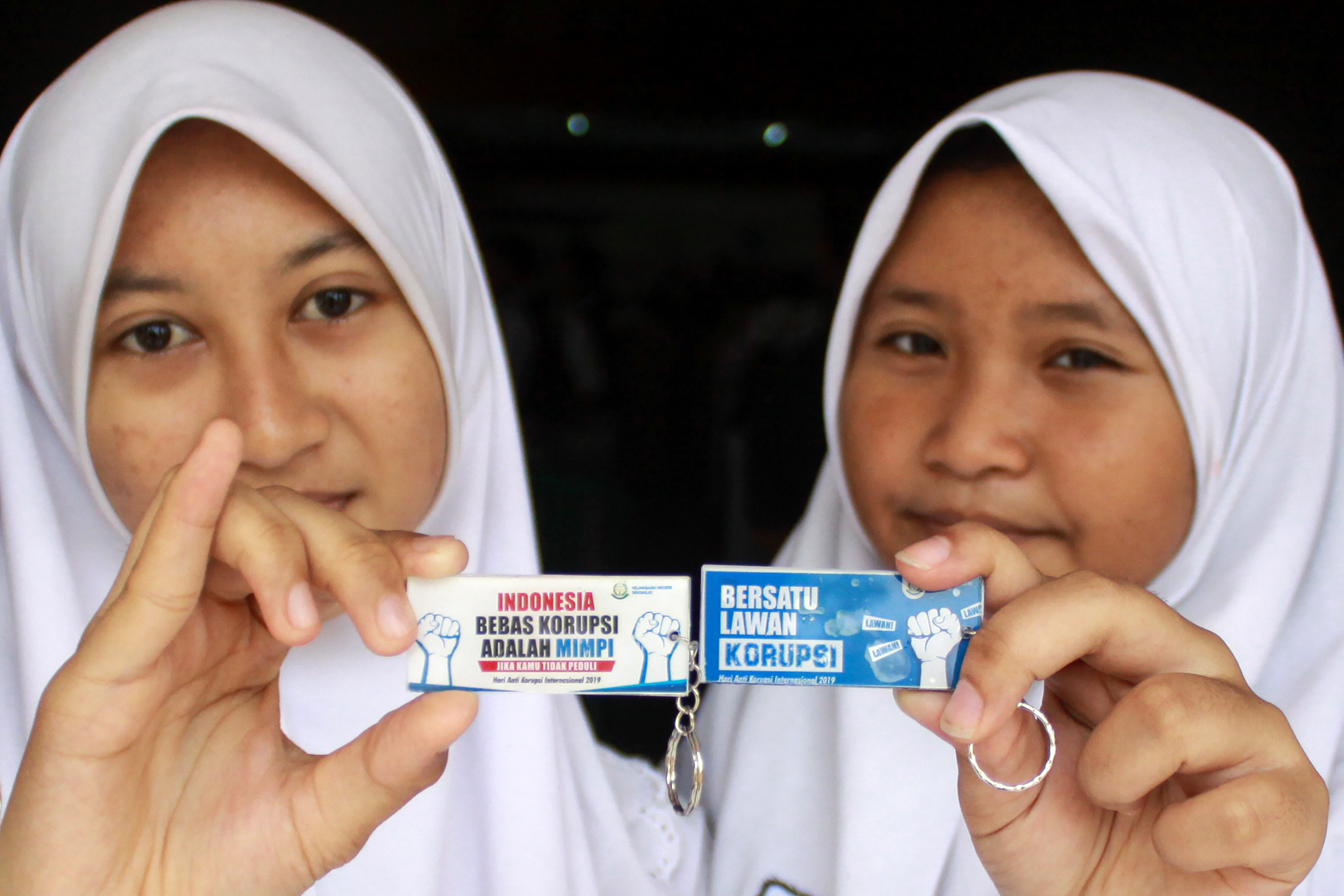 Siswa menunjukkan gantungan kunci saat peringatan hari anti korupsi sedunia di SMPN 1 Sidoarjo, Jawa Timur, Senin (9/12).