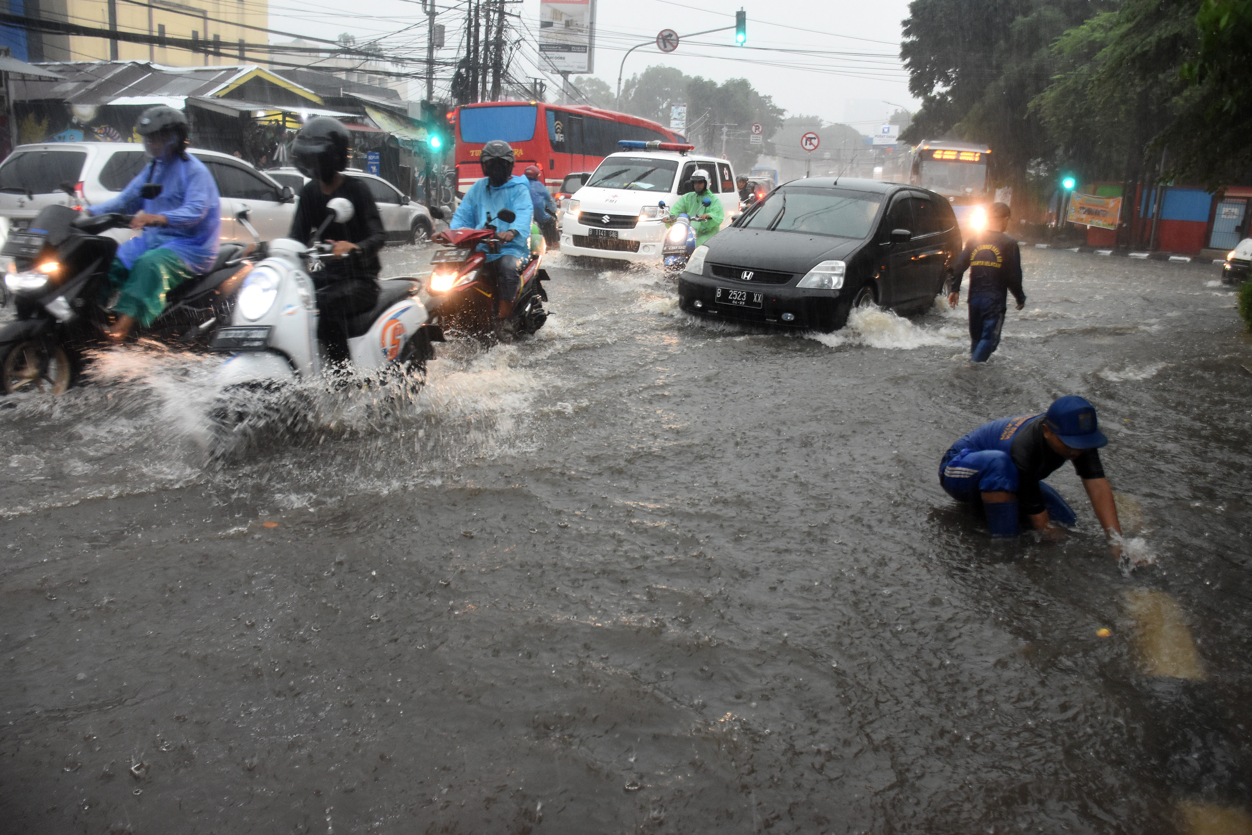  Petugas Suku Dinas Sumber Daya Air Jakarta Selatan mengecek saluran air saat banjir di kawasan Kalibata, Jakarta, Jum
