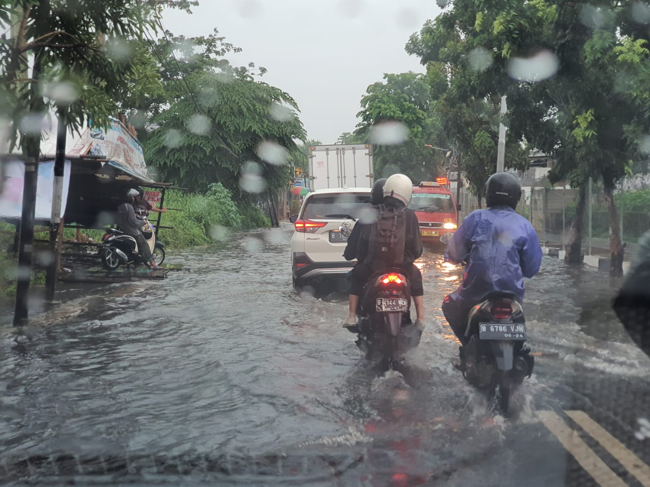 Pengendara melintasi banjir di wilayah Meruya, Jakarta Barat, Selasa (1712?