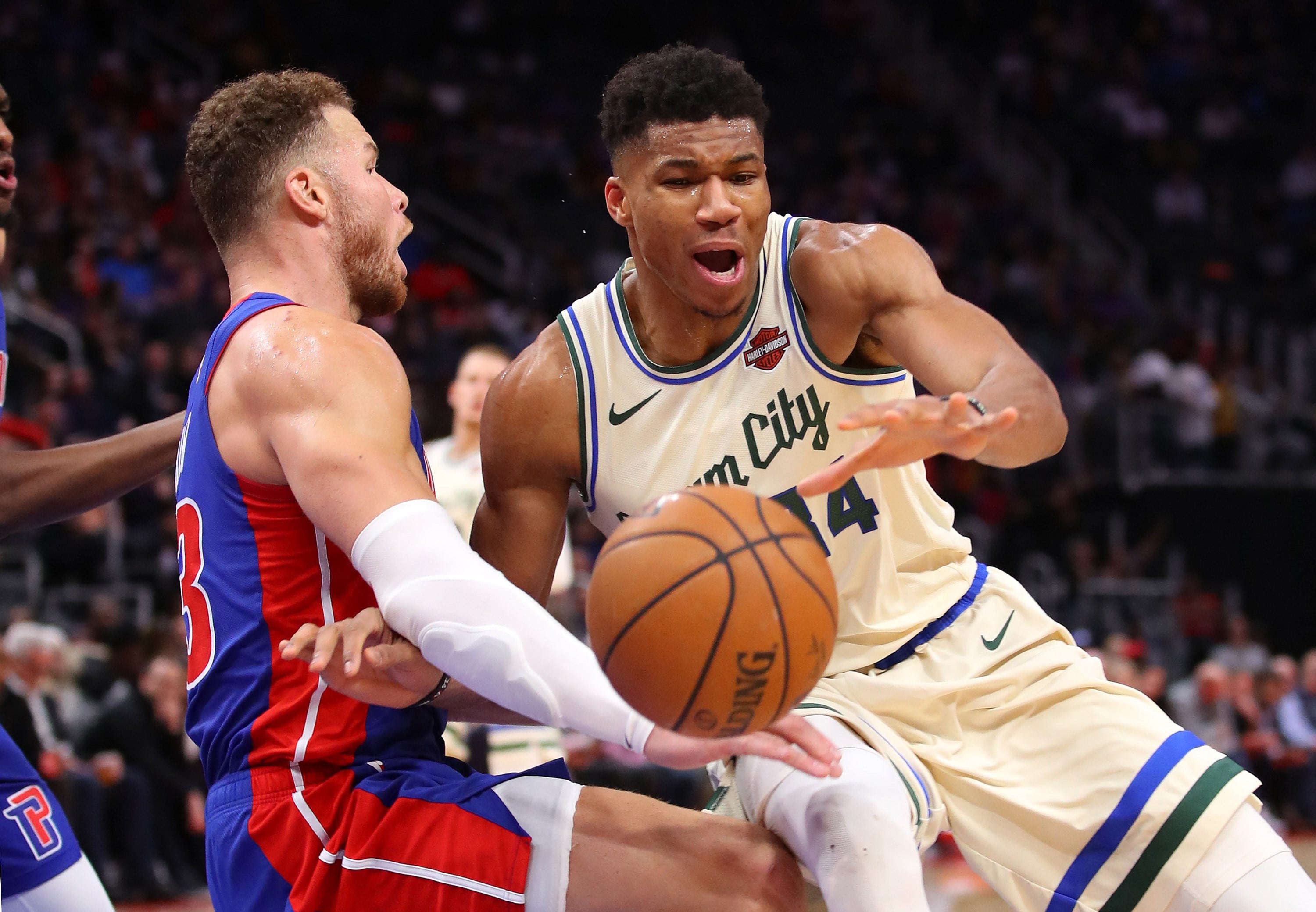 Giannis Antetokounmpo (kanan) dari the Milwaukee Bucks membawa bola dan dihalangi  Blake Griffin dari Detroit Pistons.