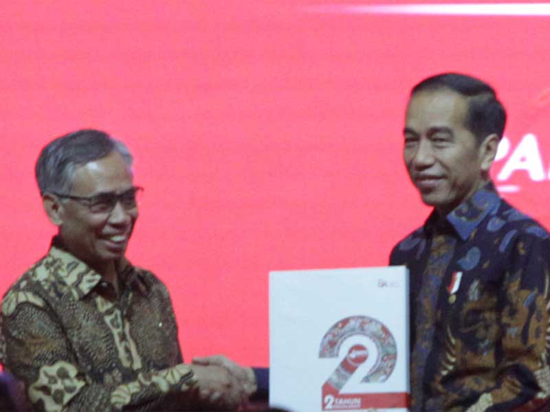 Ketua Dewan Komisioner OJK Wimboh Santoso (kiri) menyerahkan buku dua tahun Bank Wakaf Mikro (BWM) kepada Presiden Joko Widodo.