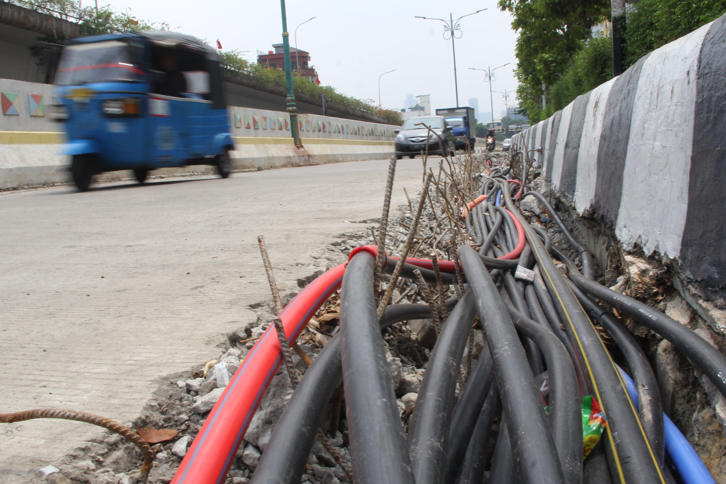 Sejumlah kendaraan melintas di sebelah penataan kabel di kawasan Matraman, Jakarta Timur.