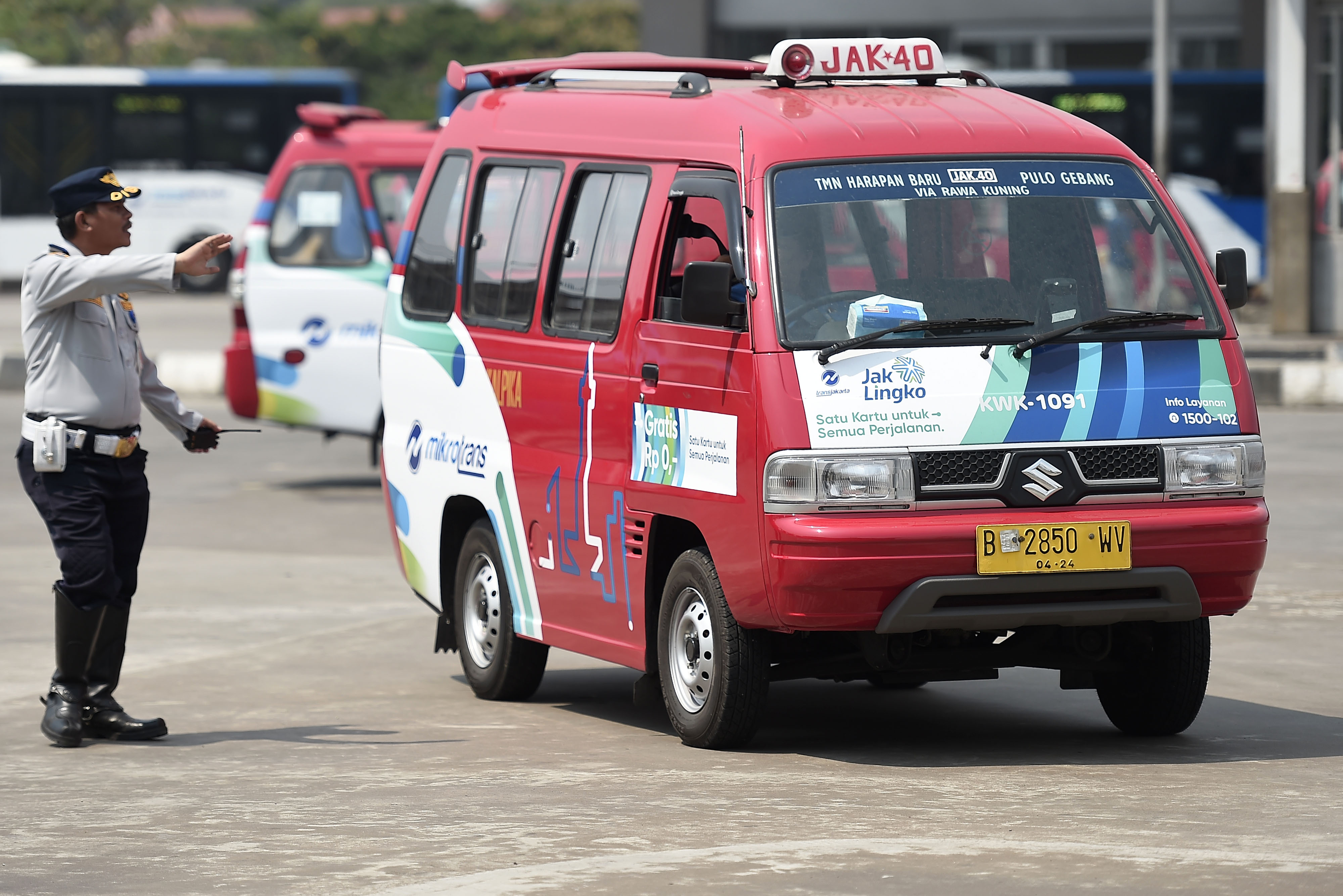 Petugas mengatur arus kendaraan angkutan kota (Angkot) di Terminal Bus Terpadu Pulogebang, Jakarta Timur, Jumat (2/8/2019).