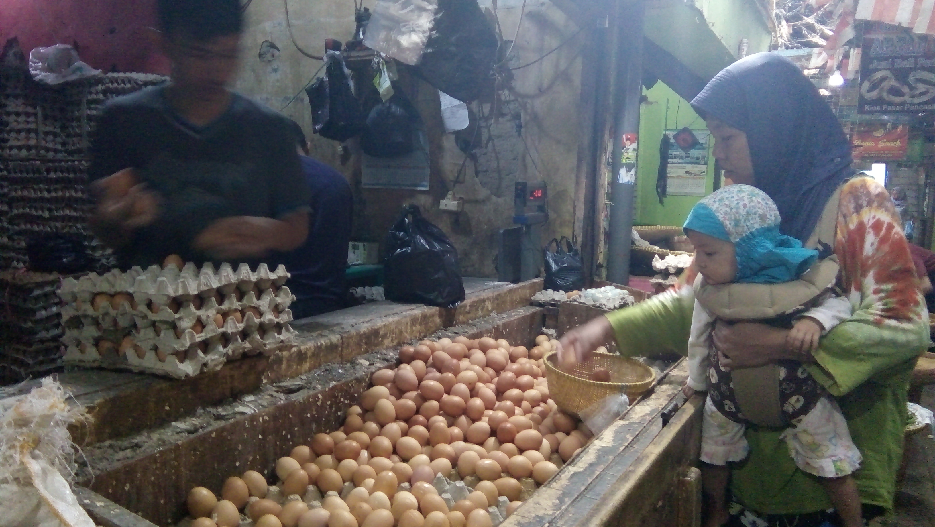 Seorang ibu sedang membeli telor di Blok C Pasar Pancasila. 