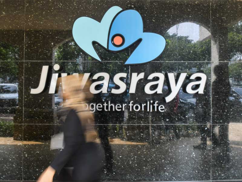 Warga melintas di depan kantor Asuransi Jiwasraya di Jalan Juanda, Jakarta.