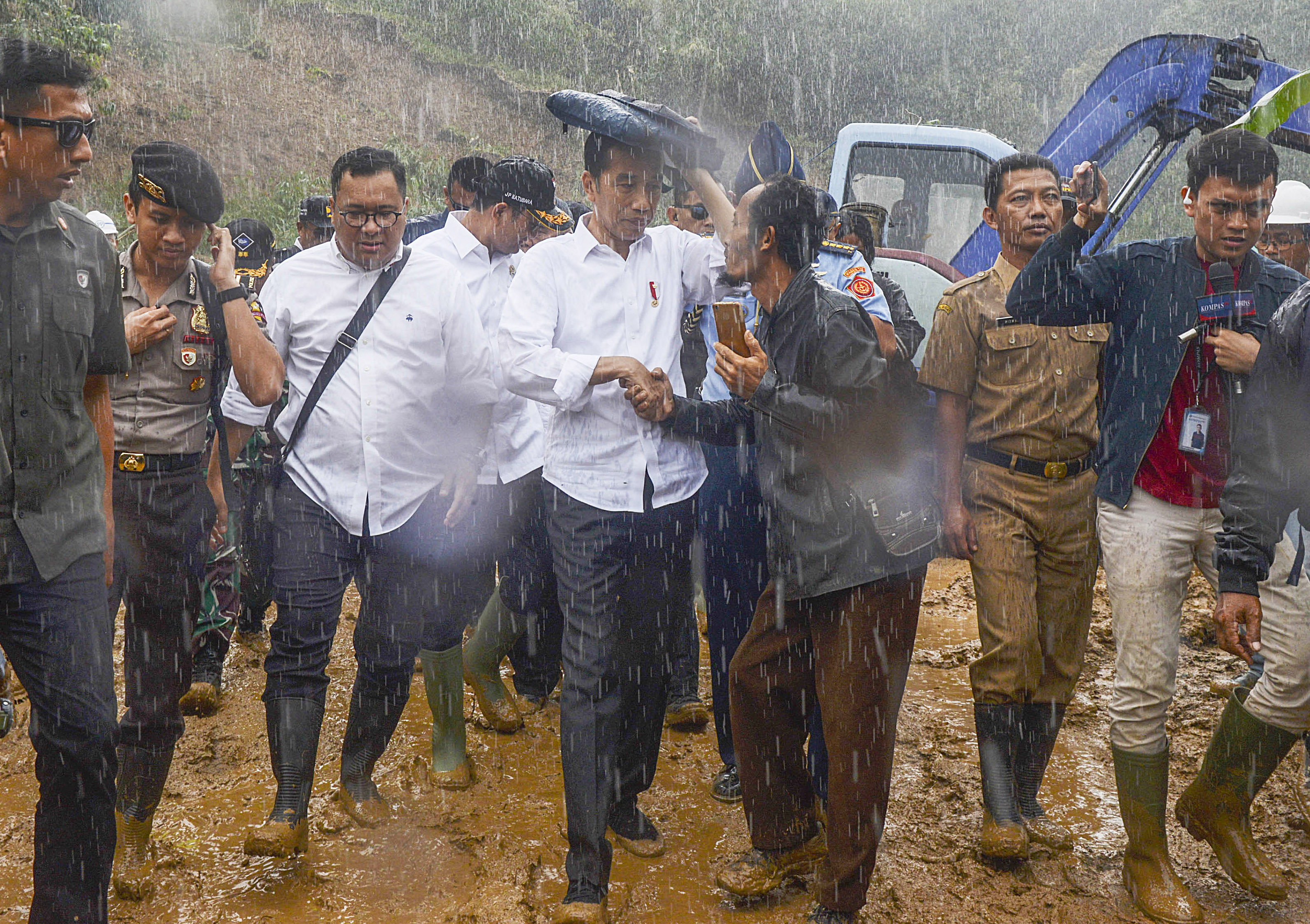 Presiden Joko Widodo (tengah) mengunjungi daerah terdampak longsor dan banjir bandang di Desa Harkat Jaya