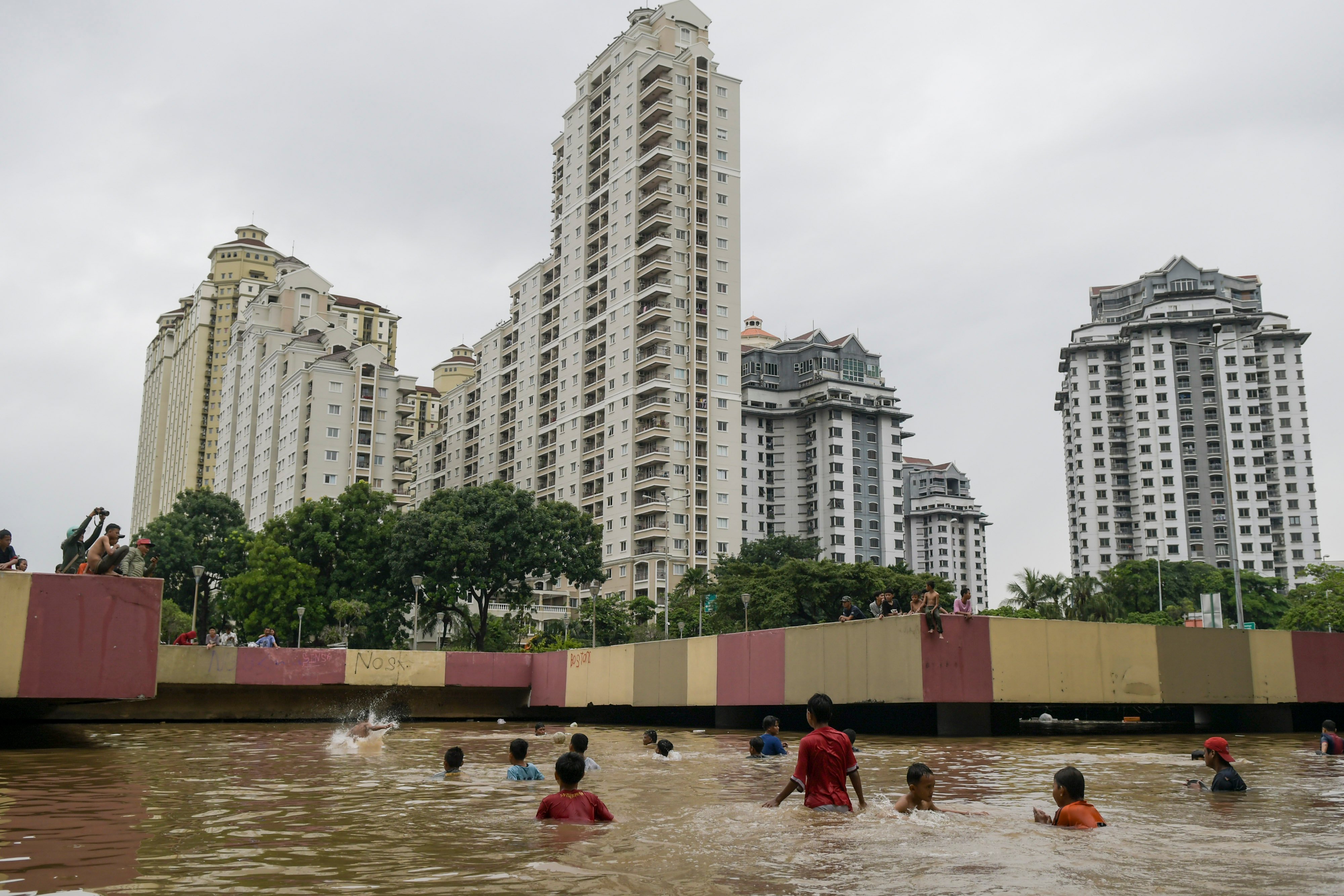 Sejumlah anak bermain saat banjir menutup terowongan di jalan Kota Baru Bandar Kemayoran, Jakarta.