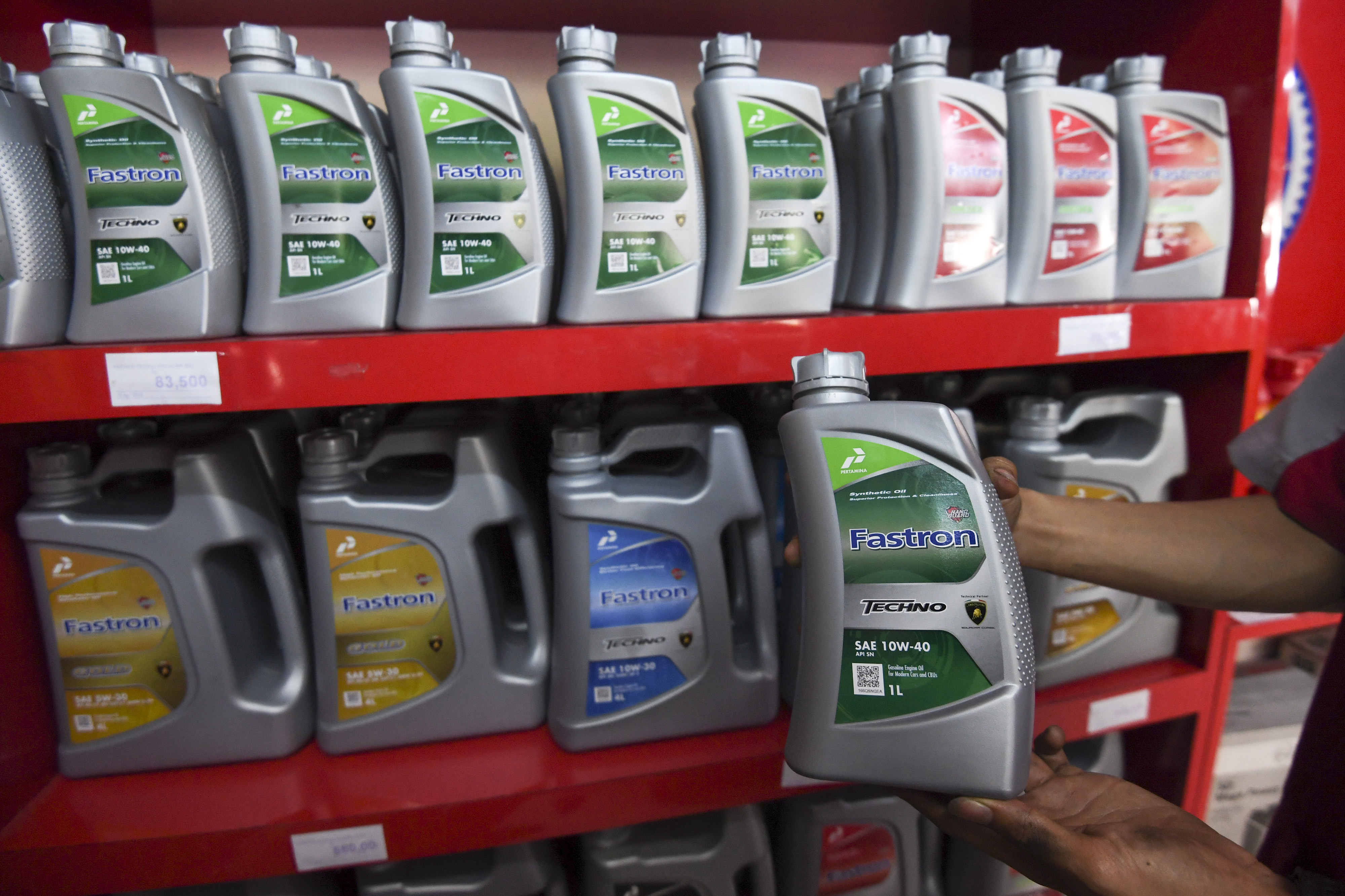  Montir menunjukan pelumas mesin kendaraan di gerai penjualan oli di Jakarta,beberapa waktu lalu.  