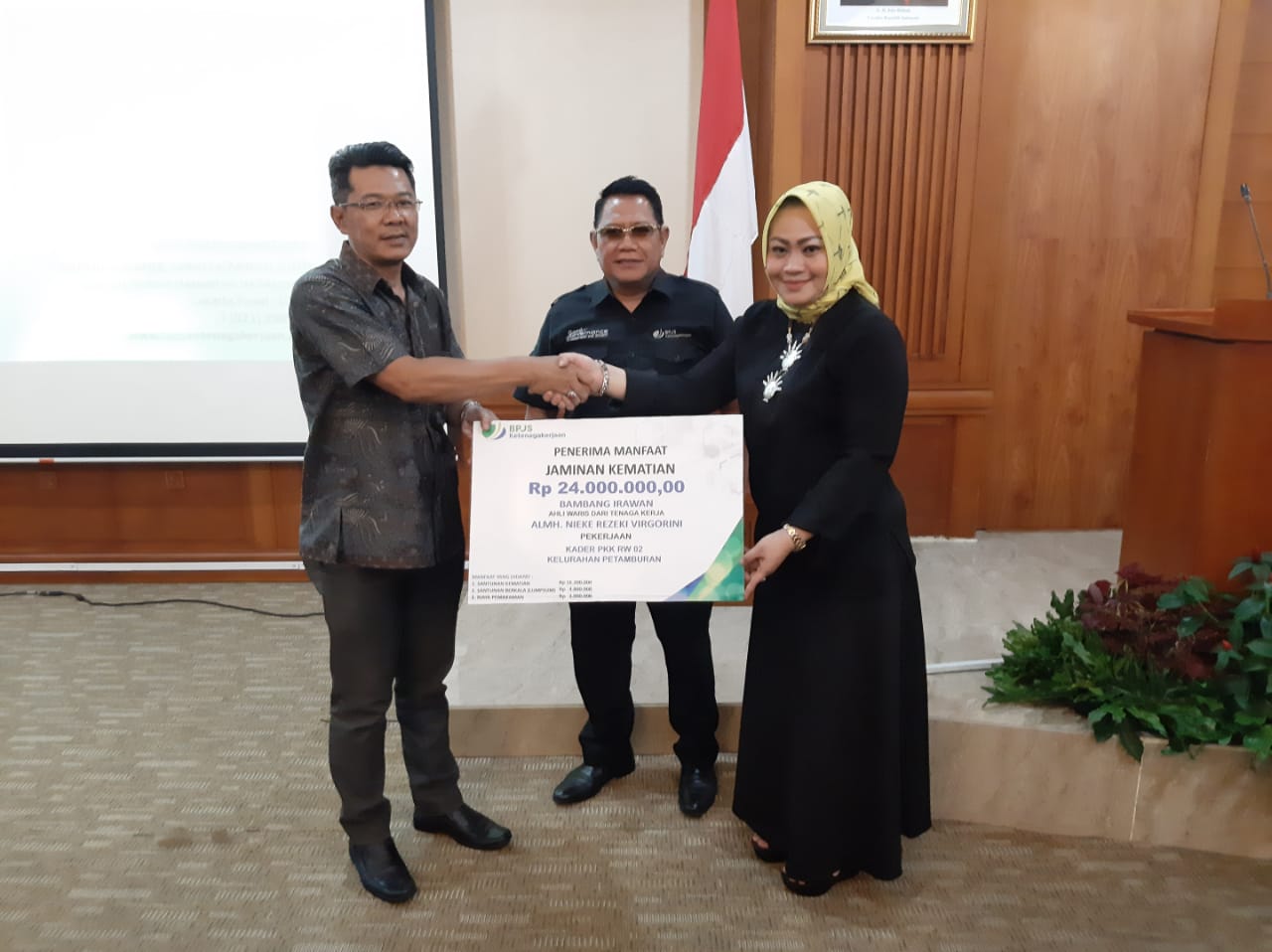 Ketua TPPKK Jakpus Sinthya Ayuningrum (kanan) menyerahkan santunan program JKM disaksikan Kacab BP Jamsostek Kebon Sirih Tonny W.K (tengah)