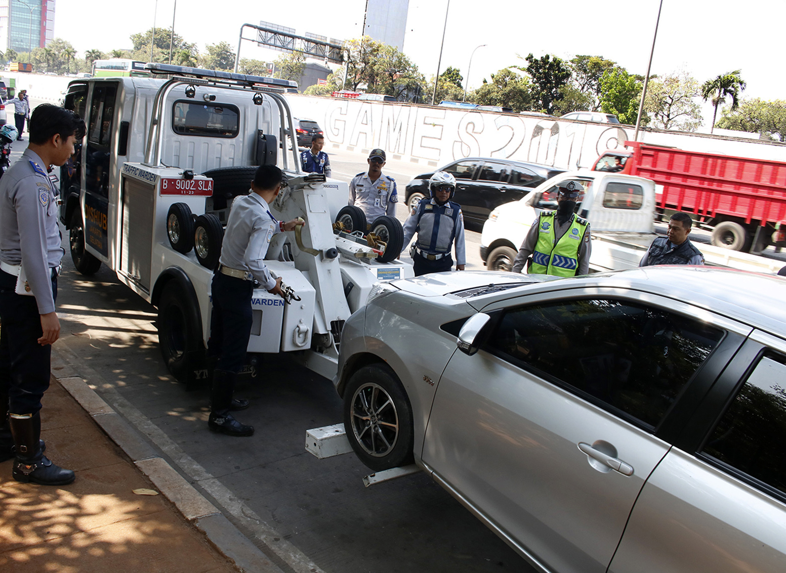 Petugas Dishub DKI menderek mobil yang parkir sembarangan di Jalan TB Simatupang, Jakarta.