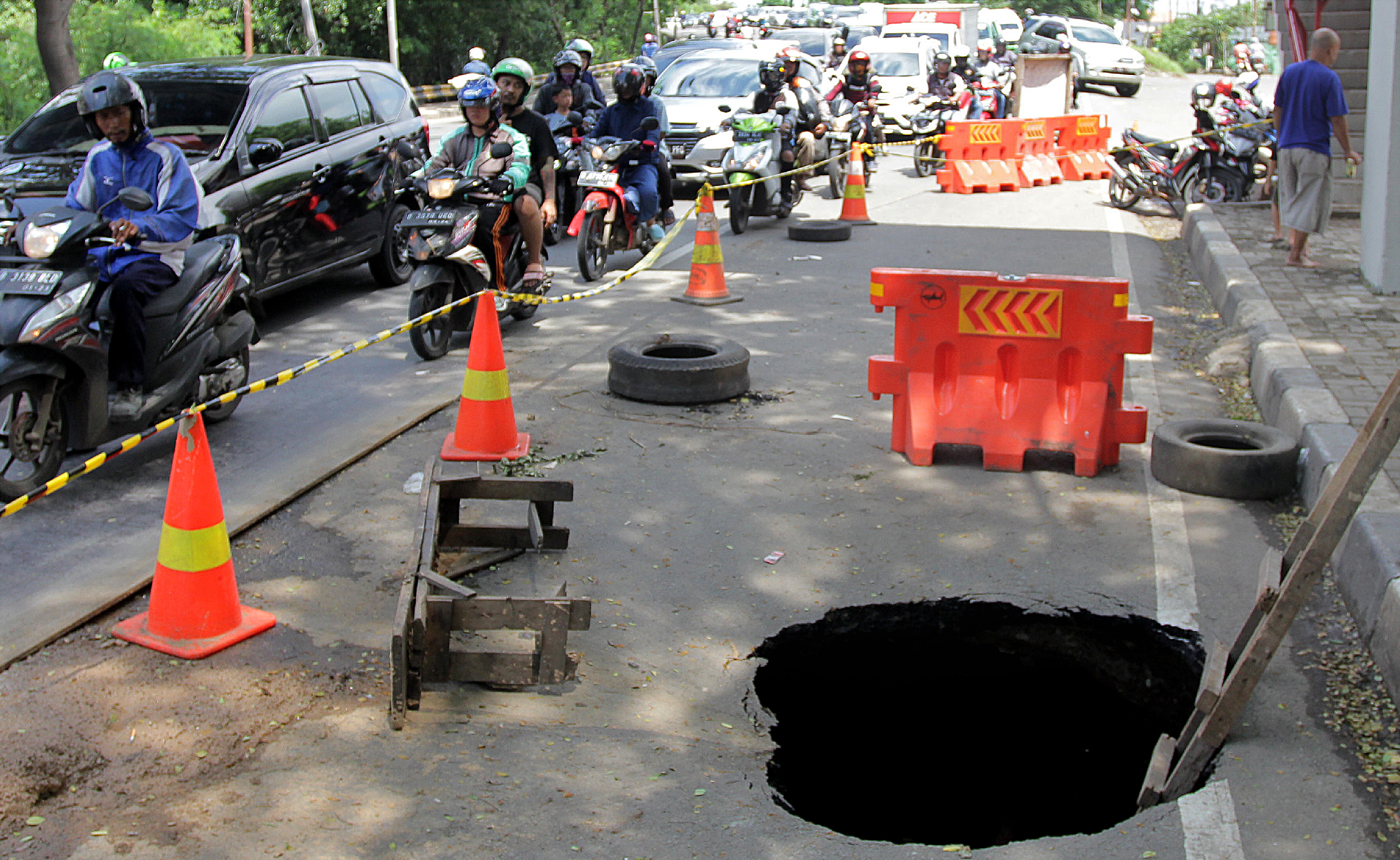 Jalan berlubang akibat ambles di Jalan Daan Mogot, Tangerang, Banten.