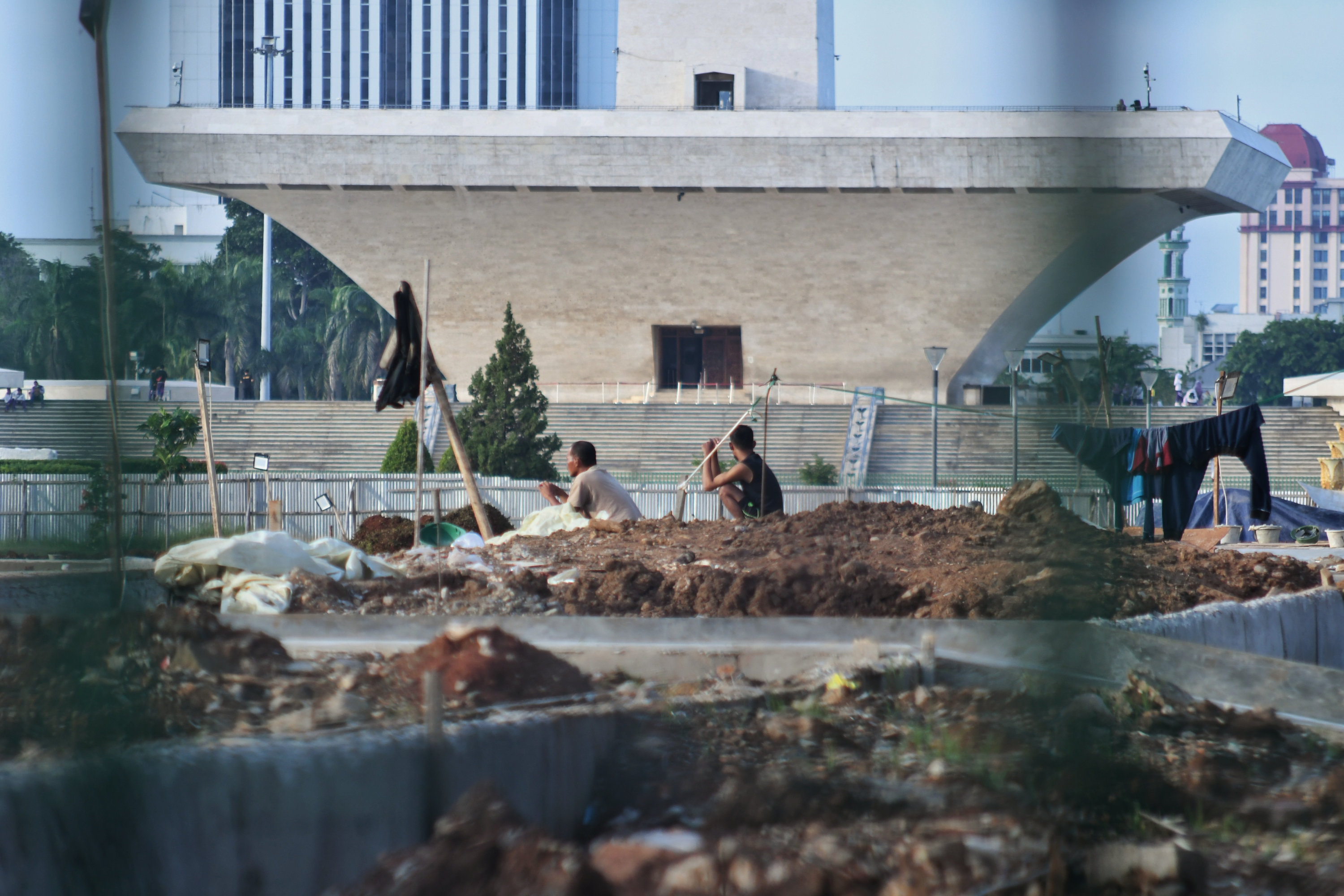 Aktivitas para pekerja usai diberhentikannya proyek revitalisasi di sisi selatan Monumen Nasional.