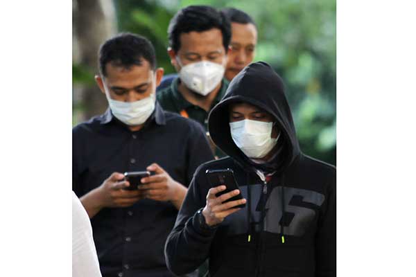 Sejumlah karyawan menggunakan masker saat keluar dari gedung BRI 2, Jakarta, Kamis (23/1/2020)